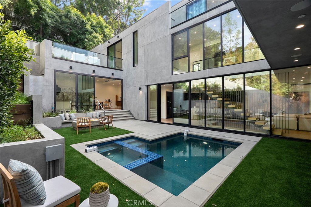 A true architectural gem, this stunning new-construction home with dramatic Valley views is tucked away in the hills of Studio City on a quiet cul-de-sac. A sleek, modern exterior welcomes you into a warm interior filled with natural woods, imported stone and expansive walls of glass that bathe the space in natural light. Thoughtfully designed for both everyday living and entertaining, the open-concept layout is anchored by a spacious family room that flows seamlessly into a gourmet chef’s kitchen equipped with top-of-the-line Miele appliances, an oversized island with seating and walk-in pantry. Slide open the floor-to-ceiling glass doors and step out to your sun-drenched central courtyard – complete with a sparkling pool/spa, cozy built-in fire pit and ample space for lounging or enjoying an al fresco meal. Rounding out the main level is an inviting living room, formal dining room and chic powder bathroom. A sleek floating staircase leads you upstairs, where you’ll find four generously sized ensuite bedrooms, including an impressive primary suite that features a private patio, custom walk-in closet and sumptuous bathroom, boasting a soaking tub, rainfall shower and dual vanities. Up another level, there’s a bonus room with a wet bar and full bathroom that opens to an expansive rooftop terrace, offering breathtaking vistas of the Valley – perfect for entertaining or relaxing while you watch the sunset. Additional highlights include a lower-level ensuite bedroom, laundry room, high ceilings throughout, smart home features like integrated speakers, a state-of-the-art security system and three-car garage. Ideally located South of the Boulevard within the top-rated Carpenter School District, this exceptional property is just moments away from trendy restaurants, boutique shops, Fryman Canyon hiking trails and so much more. This is modern luxury living at its finest!