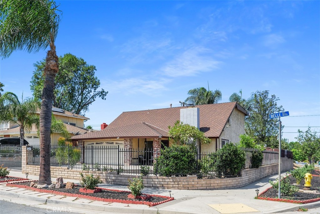 Two story home on a large corner lot enclosed, on one side and front, by a wrought iron fence and gate. Spacious back yard with a covered patio area that spans the width of the house, ideal for spending afternoons outdoors and entertaining friends and loved ones. There is a gated playground area that includes a slide and swings, plus a shed for extra storage. One side of the lot is lined with built in planters, perfect for your favorite flowers, plants, herbs or your own vegetable garden. You won't have a problem with parking. Two car garage plus an oversized driveway. The home offers 4 bedrooms, 2 bathrooms plus a large storage room that can be used for multiple purposes. One of the four bedrooms is located on the main level with direct access to the downstairs bathroom and French doors to the backyard area. The upstairs bathroom has recently been remodeled with updated vanity, mirror, light fixture, flooring and toilet.