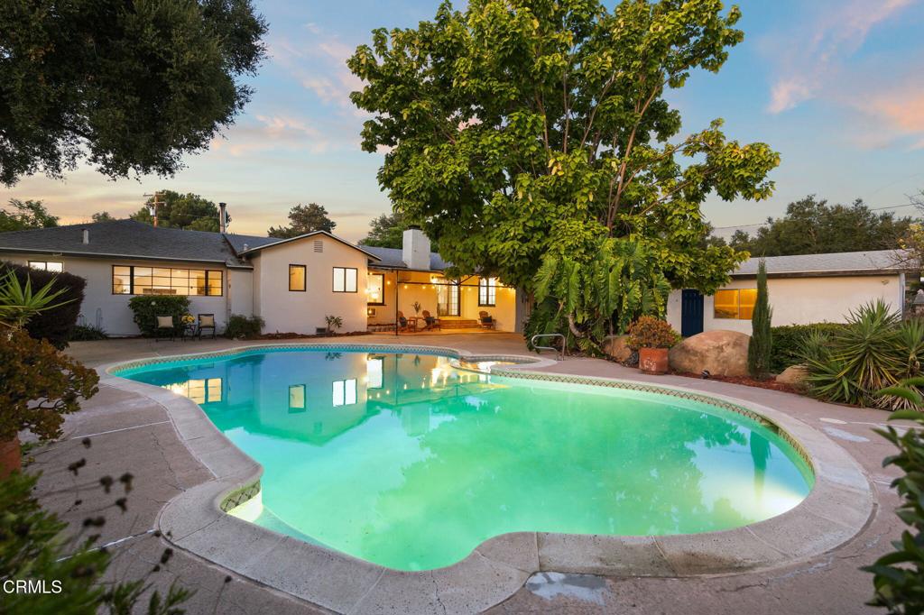 Escape to your own tranquil haven in this mid-century ranch-style home that blends rustic character with comfort. Set on nearly 0.37 acres, 1182 Lake Avenue invites you to unwind and entertain with gracious single-story living including 4 possible bedrooms + 2.5 baths, and more than 2,100 sq ft of open, airy spaces. (2 bedrooms have closets) The west wing of house can easily serve as separate living quarters with a large living space, half bathroom, and 2 rooms. The heart of the home is the country kitchen with sunny breakfast area, opening to family and dining rooms ideal for morning light or evening gatherings by the wood-fire fireplace. Newer roof, electrical panel & recent cosmetic updates. Outside, enjoy a lush mini orchard, flourishing gardens, and an in-ground pool & spa for year-round relaxation. Practical-minded extras include RV-friendly stamped driveway, deep two-car garage with workspace, and abundant parking. Located in the friendly, picturesque Mira Monte area, this home gives you the balance of peaceful rural charm and easy access to Ojai's shops, Ventura & Santa Barbara, and natural escapes like Lake Casitas. Your retreat begins here. Cameras with audio at property. Please do not go direct.
