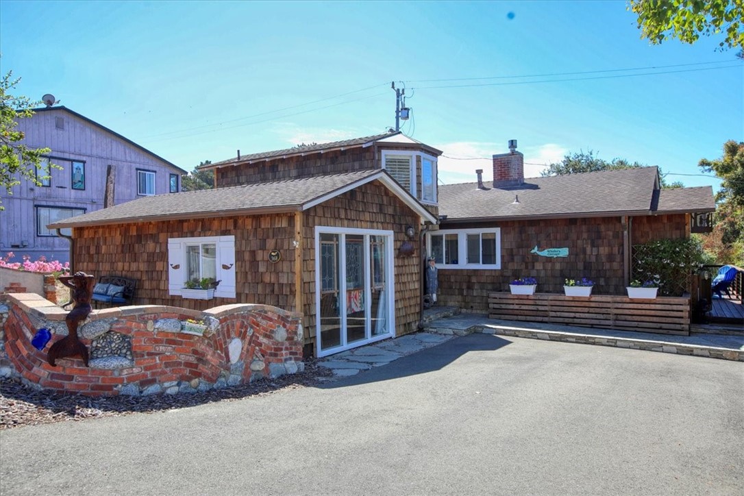 Cambria meets Cape Cod in this quaint, cute New England-style cottage! This 1,516 square foot SINGLE LEVEL home is located just three blocks from the boardwalk at Moonstone Beach and the ocean. This super clean home has an open floor plan and original hardwood flooring throughout much of the house. The current owners have made several updates, including a brand new BEAUTIFUL kitchen with stainless steel appliances and soft close cabinetry. The detailed woodworking can be seen throughout the house, particularly in the living room, with a huge built-in bookcase and fireplace mantle. Make sure you spend a minute staring over the top of the Dutch door out towards the Pacific Ocean. One of the best parts is not inside, but outside! This ocean view charmer includes two lots to the rear, which are meticulously cared for, offering multiple sitting areas, two TuffSheds, a bocce ball court and RV/boat parking. The front of the house has a whimsical new custom stone wall. The inside of the house has an extremely private feel, aided by vacant lots on all three sides.