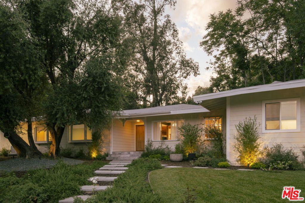 Welcome to 4901 Palo Dr., Tarzana, a stunning modern California ranch located south of the boulevard in one of the area's most prestigious neighborhoods. This 3,338 sq. ft. family home sits on a spacious lot just under a half-acre, offering both privacy and luxury with designer finishes throughout no expense spared. Step inside to discover an open-concept layout with oversized living spaces and bedrooms, designed for both comfort and entertaining. The custom chef's kitchen is a dream, featuring top-of-the-line Viking appliances, custom millwork, and quartz countertops perfect for cooking enthusiasts and family gatherings. The kitchen also includes a cozy breakfast table area, ideal for casual meals, while the formal dining area provides the perfect setting for more elegant entertaining. Off of the living room, you'll find a stylish bar, perfect for mixing drinks and hosting guests in a relaxed yet sophisticated setting. This home offers all of the modern amenities and designer finishes, while still maintaining a cozy, welcoming atmosphere perfect for family life. It features 3 spacious bedrooms, including a primary bedroom with a walk-in closet and a large, dreamy bathroom. Two of the bedrooms are en suite, each with their own private bathrooms, while the third bathroom is a full bathroom that serves the rest of the home. The property also includes a versatile bonus room that can serve as a guest room, home office, or media space. Expansive windows and high-end finishes create a seamless blend of sophistication and comfort. The large backyard offers endless possibilities whether you're playing with kids, barbecuing, entertaining under the stars, or simply enjoying the peaceful surroundings. The home is complemented by well-groomed pristine landscaping, adding to its appeal and charm. For added convenience, the home includes an attached large 2-car garage. Located in a prime Tarzana neighborhood, you're just minutes from high-end shopping, fine dining, top-rated schools, and scenic hiking trails. A true gem don't miss your chance to own this modern family masterpiece!