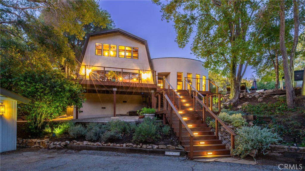 Nestled alongside the running creek with tree top views of the Santa Monica Mountains is this newly painted and ultra-private rustic Monte Nido hideaway with three large bedrooms, two bathrooms, and boasting 2,726 square feet of serene living space. As you enter the home and pass through the rebuilt Brazilian IPE front deck, you will be greeted by a large open concept living space with a large island kitchen. Tons of natural light light flood the entire floorplan through newer windows and sliders installed in 2022. The main level also includes a living room with gorgeous views and large Primary Suite. Upstairs you will find two large bedrooms with views and an updated bathroom. The renovated deck surrounded by mature oak trees, and the Flagstone patios and pathways throughout offer the perfect relaxation spot for quiet time at home or entertaining. The property contains two separate driveways for added convenience. Just beyond the almost acre lot, you’ll find numerous hiking and biking trails, including the Backbone Trail.
A bonus recording studio with the peaceful ambience creates quite the sanctuary for creatives and work from home enthusiasts alike. A fantastic location offering seclusion, and also only 10 minutes to the beach, restaurants, shopping, and freeway. A truly special offering.