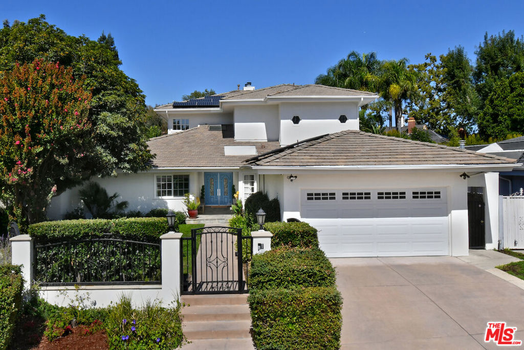 Welcome to this private, gated, two-story traditional with a pool on a quiet cul-de-sac in the award-winning Lanai Road School District! This beautiful home offers 5 bedrooms + large den & 5 bathrooms, and a detached guest house with a kitchenette, bathroom and living area. An ideal layout for family living, multi-generational living, entertaining and those who want a live/work sanctuary. The home features hardwood floors and gorgeous crown moldings throughout, a skylight entry, eat-in cooks kitchen which opens to the family room, a living room with a stone fireplace, and an elegant formal dining room with wainscoting. The first floor also features four bedrooms, including one large bedroom which opens to the pool area and could be used as a screening room, a large play room or a second primary bedroom. The second floor boasts a "Four Seasons" style primary suite with an office, a den/sitting room with a wet bar and double fireplace to the bedroom, a balcony overlooking the backyard, two spacious walk-in closets, and a primary bath with dual vanity sinks, a spa tub, and steam shower, plus a workout or yoga room which could also be used as 6th bedroom or nursery. The home features sliding French doors leading to a private backyard patio and grassy yard with a built-in BBQ, as well as a beautiful stone patio surrounding the salt water pool and spa. Other amenities include: new roof with solar, security system, laundry room and a 2-car garage. This private oasis is supremely located on a quiet street south of Ventura Blvd and just minutes from boutiques, restaurants and daily essentials. Don't miss this gem!