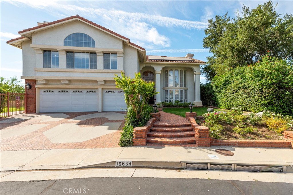 Experience luxury living in the prestigious Porter Ranch Estates community. Step into the grand foyer and be welcomed by an elegant living room featuring soaring ceilings, a custom floor-to-ceiling fireplace mantel, and expansive windows adorned with designer treatments. The space seamlessly flows into a formal dining room with scenic views of the backyard. The recently remodeled gourmet kitchen boasts granite countertops, a center island, and a built-in refrigerator, perfect for culinary enthusiasts. Upstairs, the master suite offers a serene retreat with its own fireplace, private balcony with sweeping 180-degree views, custom closets, and a newly remodeled en-suite featuring marble flooring, dual sinks, a vanity area, oversized shower, and a luxurious soaking tub. Two additional spacious bedrooms upstairs provide picturesque views and feature new flooring. The bonus room, with its vaulted ceiling, fireplace, and wet bar, offers versatility as a home office or potential fifth bedroom. Downstairs, a well-appointed guest suite provides privacy and comfort. Step outside to the tranquil backyard, where you’ll find a large grassy area, covered patio, custom BBQ, and cozy seating space, all complemented by a charming white gazebo with 360-degree views. Enjoy an array of HOA amenities, including tennis courts, a swimming pool, spa, playground, and park, all for a low monthly fee. Conveniently located near shopping, dining, freeway access, and The Vineyards Shopping Center. Don't miss this incredible opportunity to own a stunning home in Porter Ranch Estates!