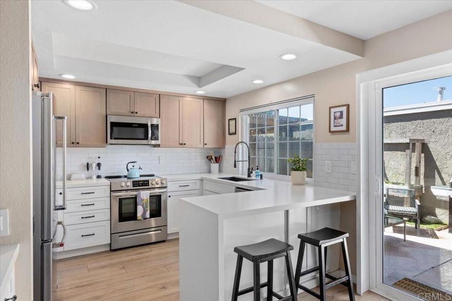 Pride of ownership shines in this remodeled, 3 bedroom, 2.5 bath, 1,492 square foot townhome with a private backyard and attached two-car garage. The home is thoughtfully upgraded with CoreTec luxury vinyl plank flooring, recessed lighting, plantation shutters, and central AC, plus a brand-new roof for peace of mind. The welcoming front patio leads into a light-filled living room with high ceilings and a fireplace, flowing seamlessly to the dining area and kitchen. The remodeled kitchen is warm and pristine, showcasing updated cabinetry, quartz countertops, stainless steel appliances, breakfast bar seating, and a lovely kitchen nook that opens to the large backyard patio and two-car garage. Upstairs, the primary suite offers a private balcony, en suite primary bath with dual sink vanity, and walk-in shower. The second floor is complete with two spacious secondary bedrooms with ample closet space, and a beautifully finished additional bath with shower-bathtub combo. Enjoy amenities within the tight-knit Vida Pacifica community, including a recently resurfaced pool and spa, and a playground. Ideally located 3.7 miles from the beach and downtown Encinitas, and just minutes to Flora Vista Elementary, Diegueno Middle School, Trader Joe’s, Sprouts, Target, parks, and favorite local coffee shops and restaurants. This inviting townhome combines comfort, convenience, and coastal living in the heart of Encinitas.