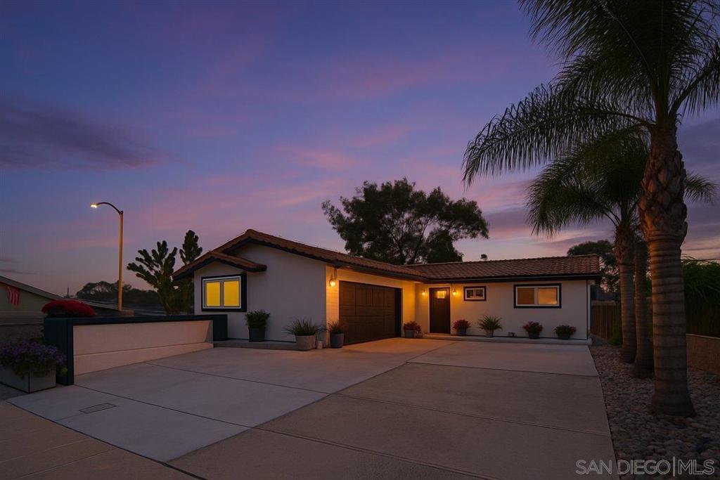 Perched atop a gentle mesa with southerly views of distant hills, the tastefully remodeled single-story main home is positioned on a corner lot within a welcoming cul-de-sac. Showcasing versatility and value, this residence includes a fully permitted, separate NEWER CONSTRUCTION ADU—ideal for multigenerational living, guest accommodations, or income potential. An oversized driveway and striking custom wood-and-glass entry door set the tone for the stylish interiors. Inside, a spacious living room is anchored by a stone fireplace with a dramatic custom wood accent wall and sconce lighting. The open floor plan flows seamlessly into the family-style chef’s kitchen, where an expansive hi-low granite island with gas cooking and a built-in breakfast counter for six invites gathering. Stainless steel appliances, abundant cabinetry, and distinctive pendant and recessed lighting enhance both form and function, while the adjacent flexible dining area repeats the custom wood accents to create an elegant yet inviting ambiance. Beautiful porcelain tile floors carry throughout the home, leading to a serene primary suite with an upgraded designer-finished ensuite bath. Four additional bedrooms, including a converted garage, provide generous accommodations. The backyard extends the living space with tri-fold doors to bring indoor/outdoor living with a large private patio featuring a shaded wood pergola and fire pit, complemented by a second covered patio ideal for evening breezes. Additional amenities include owned solar panels, dual-pane windows, A/C, ceiling fans, and a low-maintenance landscaped yard and turf! With its blend of thoughtful upgrades, flexible living spaces, and proximity to parks, schools, shopping, restaurants, and freeways, this property offers both sophistication and everyday convenience.