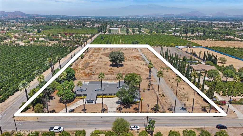 Amazing Arlington Heights opportunity! Prime location just east of the California Citrus State Historic Park. Unobstructed views in all directions. FLAT 5 acre parcel with Gage Canal water shares (discounted agricultural water)...ideal for citrus, avocado, nursery business, etc. Plenty of space for a barn, shop, sports court, and complete equestrian facilities. Zoned RA-5 (5 acre minimum) makes this part of town one of the MOST desirable for for custom homes and estates. Flexible floorplan, ideal for multigenerational living, 6 bedrooms ALL on the first level, separate entry along the eastern edge of the home could become an ideal ADU within the existing floorplan and still utilize 5 bedrooms for the main home. Open kitchen, spacious family room, 3 fireplaces (including one in the primary suite). This could be transformed into one of the most impressive estates in the area. Gated circular driveway, detached garage with ample storage, multiple entry gates including the western edge along Irving Street.