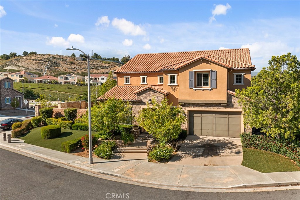 Stunning Model Home with Over $500K in Premium Upgrades! Welcome to an extraordinary opportunity in the prestigious Sterling at West Hills community. Nestled on a large corner lot in a quiet cul-de-sac and surrounded by breathtaking mountain views, this highly upgraded model home offers over 4,300 square feet of luxurious living space, featuring 5 bedrooms, 6 bathrooms, and every modern amenity imaginable. Step inside to soaring ceilings, rich natural light, and a seamless flow that blends elegance with comfort. The main level features a desirable private guest suite complete with a sitting room, full bath, and walk-in closet—ideal for multigenerational living or visiting guests. Also on the main level is a dedicated office—perfect for working from home in comfort. At the heart of the home lies the chef’s kitchen equipped with a massive center island, custom cabinetry, double Wolf ovens, dual dishwashers, a built-in Sub-Zero refrigerator, and an expansive walk-in pantry. The kitchen opens to an inviting great room with a striking fire feature and panoramic glass doors that frame serene mountain vistas. Step outside to a true entertainer’s paradise. The backyard boasts a covered patio, built-in BBQ, grassy play areas, and a tranquil water wall with a cozy seating area—perfect for relaxing or outdoor yoga under the stars. The formal dining room also offers direct access to the outdoors. Upstairs, the primary suite is a luxurious retreat with a separate lounge or office area, two generous walk-in closets, and a spa-inspired bath featuring dual vanities, a soaking tub, and a large walk-in shower. A versatile loft provides additional living space and can be used as a playroom, gym, media room or 6th bedroom. Just off the primary suite and upstairs loft, you'll find a spacious upstairs patio with a comfortable seating area and cozy fireplace—perfect for unwinding with mountain views! Down the hall, 3 additional bedrooms include walk-in closets and private full bathrooms. Located in the award-winning El Camino and Hale Charter School District. Enjoy close proximity to Westfield Topanga Mall, The Commons, top-rated hospitals, parks, and scenic hiking trails. This exceptional home is offered with the option to be sold fully furnished. Every detail has been carefully curated—there are simply too many upgrades to list. Don’t miss your chance to own this one-of-a-kind West Hills masterpiece. Welcome to your forever home!
