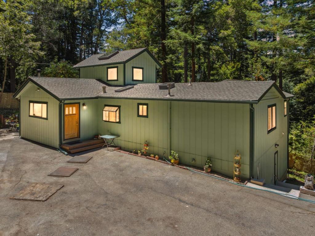 Set on three sunny parcels, this turnkey 3-bed, 2-bath home offers peace, privacy, and charm. Enjoy fresh paint, mature landscaping, a paved driveway with turnaround, and ample parking. The kitchen features a raw-edge redwood burl counter and brand-new stainless steel appliances, perfect for creating meals to enjoy in the open dining area or on the spacious deck. The primary suite is a quiet retreat, with laundry conveniently located between the bedroom and bath. A second bedroom opens to a private deck, and the upstairs loft feels like a treehouse with windows on all sides, skylights, its own deck, and treetop views. Cozy up to the wood stove, relax in the heart-shaped hot tub with sunset views, or explore the large basement for storage or hobby space. The big, flat garden is bursting with blooms, sunflowers, dahlias, hydrangeas, and more, plus apple trees, madrones, maples, oaks, and towering redwoods. Located on a quiet dead-end road near Loch Lomond and Henry Cowell parks, and just minutes from downtown Felton. Dewalt generator included. Enjoy easy access to boating, hiking, and biking at Loch Lomond and Henry Cowell parks, while downtown Felton's shops, eateries, and markets are just minutes away.