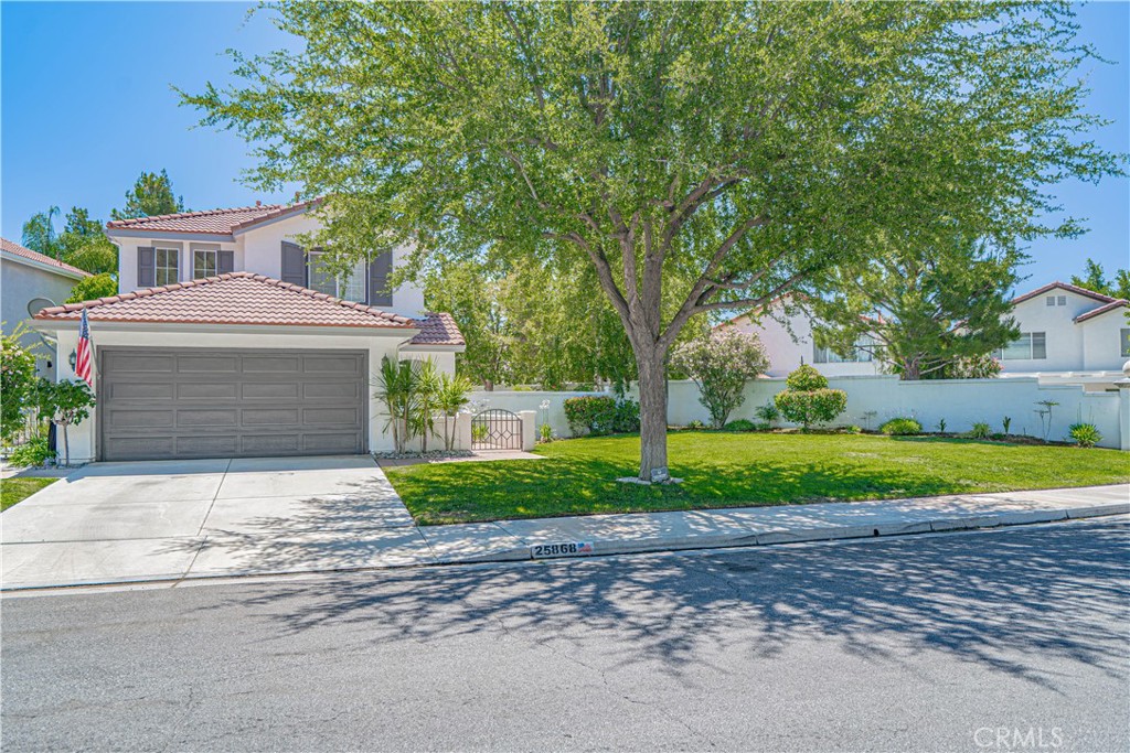Home Is Where the Heart Is with this home nestled in the highly sought-after Stevenson Ranch community, where charm, comfort, and convenience come together on a large 6,200 sq ft pie-shaped lot with no front neighbors, offering privacy and exceptional curb appeal. From the moment you arrive, you’re greeted by a beautifully landscaped huge front yard and an inviting front porch/courtyard — the perfect spot for morning coffee or evening chats. Step inside to discover a thoughtful layout featuring two spacious downstairs living areas, seamlessly connected by an elegant arched doorway transition. The formal living and dining rooms set the tone for entertaining, while the adjacent family room with a cozy fireplace and custom built-ins creates a welcoming atmosphere for everyday living. The tile flooring, custom floor moldings, Nest thermostat, and alarm system are just a few of the home’s modern conveniences. The kitchen is bright and functional with ample cabinetry, recessed lighting, a convenient eat-at bar, and open to the family room and views of the lush backyard. Upstairs, you’ll find three generously sized bedrooms, including a spacious primary suite with vaulted ceilings, a large closet, and a luxurious en-suite bathroom featuring a soaking tub, separate shower, and dual vanity. A built-in hallway cabinet adds practical storage, and the upstairs laundry closet makes everyday living even more convenient. Step outside to enjoy California living at its finest. The large backyard boasts a concrete patio with a cover, lush greenery, and an oversized side yard with additional patio space — all connected by a concrete walkway that wraps around the property. The attached two-car garage with custom cabinetry offers plenty of storage for tools, toys, or gear. This home is just minutes from freeway access, top-rated schools, shops, restaurants, and countless parks and hiking trails. Whether you’re hosting a gathering or enjoying quiet moments at home, this Stevenson Ranch gem offers the ideal blend of space, style, and location.