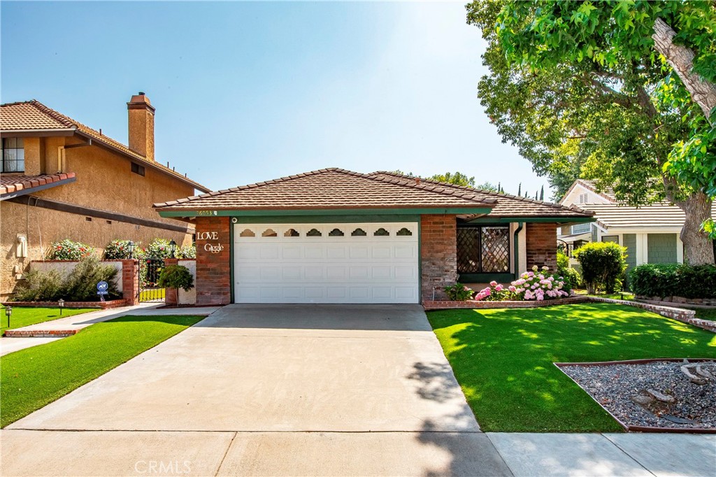 Charming Single-Story Home in Valencia’s Coveted Discovery Tract. Nestled in the highly sought-after Discovery Tract in the heart of Valencia, this stunning single-story home is a rare gem that combines modern upgrades with cozy elegance. With a PAID solar system professionally installed by Sunrun—featuring a 4.9 KW Solar system with battery backup—this home offers sustainable energy efficiency, both on and off the grid.
Step inside to find luxury vinyl plank flooring in the living room, hallway, and dining area, while the bedrooms retain the soft comfort of quality carpeting. The bright and airy kitchen, adorned with Corian countertops and included refrigerator, seamlessly flows into the dining and living room, complete with a cozy fireplace for those chilly evenings. Tech-savvy buyers will appreciate the hardwired internet system. Additional upgrades include a whole-house fan, recessed lighting with built-in speakers, and new up-high garage storage. The new furnace (2022), A/C condenser (2022), and water heater expansion tank (2020) ensure worry-free living for years to come. The master suite boasts direct access to the inviting backyard, which is adorned with peach, cherry, and lemon trees. A covered patio and in-ground custom water feature make for the perfect outdoor retreat. The upgraded bathrooms shine with custom tile, designer paint, and modern vanities. One bedroom includes a hidden Murphy Bed, adding extra convenience for guests, while new ceiling fans enhance comfort. Additional thoughtful features include a gated front entrance for added privacy, new side gate and side back door with a doggie door, and a negotiable EV charging plug in the garage. Ideally located at the end of a cul-de-sac, this home is just steps from the beloved Valencia Paseo System, offering biking and hiking trails with picturesque bridges leading to major shopping areas. With HOA fees of just $77/month currently, enjoy access to the community pool and recreation center. This exceptional home checks all the boxes—privacy, location, upgrades, and charm! Don’t miss this incredible opportunity to own a slice of Valencia paradise. Contact us today for a showing!