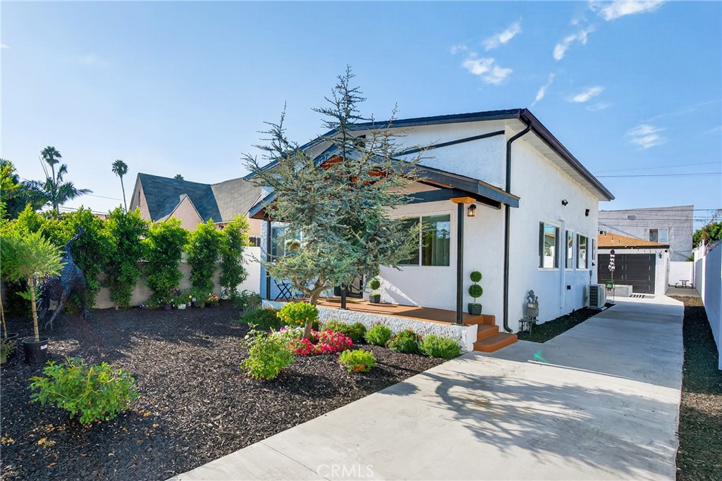 Welcome to this beautifully remodeled 2-bedroom, 1-bath single-family home where modern design meets quality craftsmanship. The bright, open floor plan features diamond-laid porcelain tile, recessed lighting, crown molding, ceiling fans, and pre-wired entertainment speakers, including in the living room. The custom kitchen is a standout with solid wood cabinets, quartz countertops, new sleek appliances. Laundry hookups are located on the service porch for added convenience. The spa-like bathroom showcases premium fixtures—including a floating toilet and glass-tiled shower. Finished with custom pearl paint from a local art shop, every detail feels elevated and unique. Outside, enjoy a gated front yard with a large covered porch, over sized garage, spacious backyard with dog run, and plenty of space for entertaining or expansion. Zoned LAR2, this property offers outstanding potential for an ADU, garage conversion, or additional units. Additional upgrades include mini-split A/C throughout, and pre-wiring for a security camera system. Conveniently located near shopping, dining, schools, and near the 105 & 110 freeways, this move-in ready gem offers comfort, style, and opportunity.