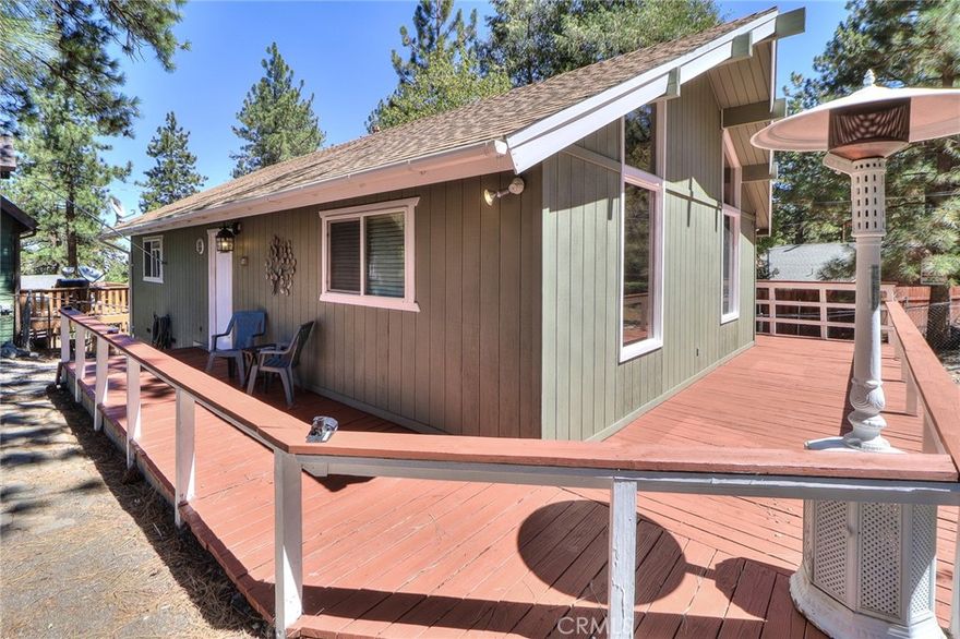 Peaceful 2 Bed + Loft, 1 Bath Mountain home on large lot with mountain views! This well-maintained, beautiful home shows true pride of ownership and is ready for you to make it your own! Set back from the street on an over 7,500 square foot lot, this home provides a tranquil getaway with plenty of room to add on, build an ADU, or trailer/ RV parking. Souring old growth trees provide privacy, and the freshly re-stained oversized wrap-around deck is perfect for enjoying the outdoors morning, noon and night. Entering through the front door and a few steps down the hall, the family room stuns with soaring vaulted, beamed ceiling and nearly floor to ceiling south facing windows featuring a wonderful tree-lined mountain view. Warm yourself by the crackling wood burning fireplace after a day on the slopes at nearby Mountain High resort. The thoughtfully designed kitchen has open sight lines to the family room with stone countertops, two-tone cabinetry with hardware, dishwasher, stove and oven. Down the hall are two good sized bedrooms and a full bathroom with shower and tub, clean and well maintained. Up the ladder is a bonus loft, with open peek-a-boo terrace view of the family room and built in storage. The hall contains a laundry closet with additional storage. Conveniently located near Wrightwood Village and Mountain High, this amazing mountain retreat is ready for you! Do not delay, schedule a showing today!