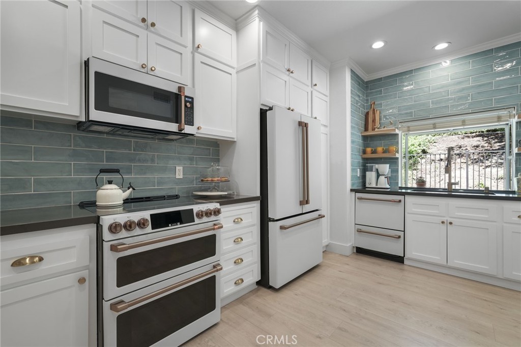 Seller offering to pre pay one year of HOA fees for new buyer(s) at current monthly rate. Credit at closing to be paid by seller directly to HOA management company. HOA currently includes all water inside the unit. Elegantly updated in 2023, this timeless home features the following: Wide plank performance grade flooring throughout (AC6 durability rated for high traffic areas, kids, and pets!), updated dream kitchen which includes soft close cabinets/drawers, quartz countertops, chef worthy café line appliances with accent champagne bronze hardware finishes, oak floating shelves, polished ceramic backsplash tile, Moen sensor touch less faucet and deep under mounted kitchen sink. Directly off this designer kitchen boasts a lovely open concept dining area, living room, charming fireplace, elaborate high ceilings, recess lighting throughout, and a gorgeous, updated half bath off the main living room for your guests. Arrive at the second floor where you can find two bedrooms each with their own on suite bathrooms and custom walk-in closets. To your right walk into a vibrant primary suite equipped with large sliding glass doors that open to a private patio and nature. Enjoy a cup of coffee or a nighttime beverage while immersing yourself In all nature has to offer. Step back inside and enjoy on suite bathroom amenities featuring modern sleek vanity, champagne bronze fixtures, honed herringbone marble floors, custom shower glass doors, and a custom walk-in floor to ceiling honed marble shower that makes your private oasis feel like an exclusive luxury spa. Encompass yourself in floor to ceiling marble and enjoy the delta Vero rainfall shower experience. Step outside your personal spa and enter into your custom walk-in closet featuring soft close drawers, shoe storage, bag storage, and ample clothing space. To the left of the second story landing boasts a stunning second bedroom which can be transformed for guests, office space, or a nursery. On suite second bedroom bath includes modern vanity, marble flooring, deep soaker tub, ceramic tile, delta Vero shower fixtures, and custom shower glass doors. Step outside this spa like experience and enter the second walk in closet of the house featuring soft close drawers, shoe shelving, and ample clothing space. Centrally located between Westlake Village, Agoura, Calabasas and highly sought after school districts!