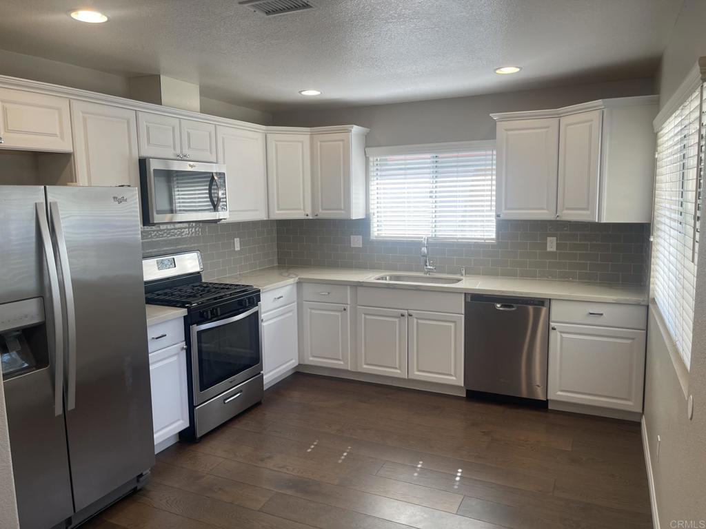 Great single story house in the Santa Fe Hills community of San Marcos with spacious fenced yard and two car garage. Wonderfully maintained home with open floorplan: kitchen with stainless steel appliances, designer sink, quartz countertops, and backsplash. Attractive flooring in main living areas, comforting fireplace, and new carpeting in bedrooms. Updated bathrooms. Washer and Dryer in garage. Situated on cul du sac street. Neighborhood features miles of walking trails, community pool, parks, and sports fields. Within walking distance to award winning school.