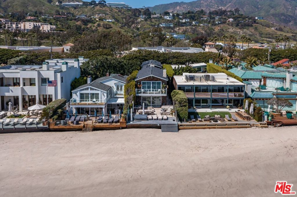 Built in 2012 this stunning home blends Traditional and Contemporary architecture and features unobstructed views and direct access to exclusive section of sandy and walkable beaches. This sought-after enclave is renowned for pristine beachfront and close proximity to local shopping, restaurants and amenities. This 6BD, 8BA home was crafted with meticulous attention to detail and boasts an expansive open floorplan. Natural light fills the home and highlights the high-end finishes throughout including dark oak flooring, travertine accents, and Carrara marble countertops. The living room offers a fireplace, ocean views, and floor-to-ceiling Fleetwood sliding doors that open to a spacious deck for indoor/outdoor living. The deck is perfect for entertaining with multiple seating areas, a firepit, built-in BBQ, spa, and has steps down to the beach. The kitchen is equipped with top-of-the-line amenities including Wolf Range and Sub-Zero fridge. The second floor offers a spacious primary suite with fireplace and private deck that overlooks the Pacific Ocean. There is a separate guest studio/suite on site that is perfect for family and friends. The garage has an electric car charger. With direct beach access, panoramic ocean views, and top-of-the-line amenities, this home is the epitome of luxury living in Malibu.
