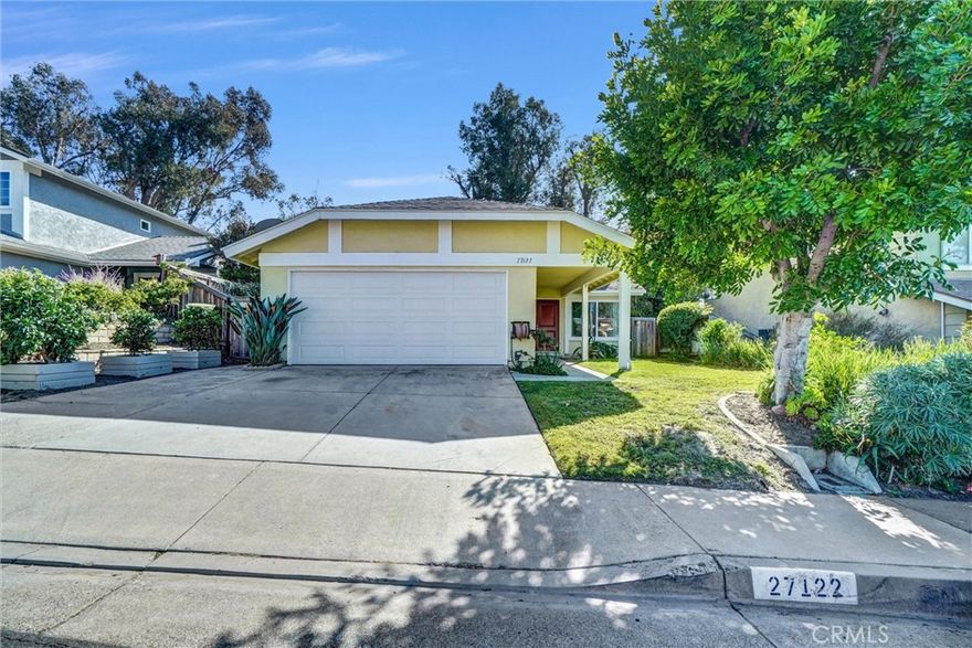 Welcome to 27122 Valleymont Road — a charming single-story cottage-style home featuring 3 bedrooms, 2 baths, 1,069 sq ft of living space on a 4,914 sq ft lot, nestled in the scenic hills of Lake Forest’s desirable Wind Rows community. From the moment you arrive, you’ll be captivated by its freshly painted exterior, lush greenery, and brick & wood planters framing the front walkway. The inviting double-door entry opens to a bright living room filled with natural light and centered around a classic brick fireplace, perfect for cozy evenings or relaxing with family. This beautifully maintained home has been tastefully remodeled, blending modern finishes with timeless character. The gourmet kitchen showcases white shaker cabinetry, quartz countertops, nickel hardware, and stainless-steel appliances, plus smart storage, including pull-out spice racks, lazy susans, and soft-close drawers. The kitchen opens directly to the dining area, and a sliding glass door leads to the serene backyard for easy indoor-outdoor living. The primary suite offers a peaceful retreat with a walk-in closet with mirrored doors and an ensuite bath featuring a freshly painted vanity with new quartz countertop, nickel fixtures, updated lighting, and a shower-in-tub. Two additional bedrooms, all with new upgraded carpet, share a beautifully remodeled hall bath with a white shaker vanity, quartz counter, black matte hardware, and a rainfall showerhead. Interior highlights include new luxury vinyl plank flooring in the living room and hall; tile in the kitchen and baths; new carpet in the bedrooms; new windows throughout with custom window coverings; new interior paint; new baseboards; recessed lighting; and updated light fixtures. The newer A/C unit and water heater provide peace of mind, and the attached two-car garage includes built-in cabinetry and laundry hookups. Step outside to a private backyard sanctuary with two modern deck areas, a custom bench, lush landscaping, and beautiful views of the adjacent park and surrounding hills — ideal for morning coffee, weekend barbecues, or peaceful evenings outdoors. Located near Vintage Park, with convenient access to the 241 Toll Road, Saddleback Valley Unified schools, low taxes, and no Mello-Roos, all close to shopping, dining, and recreation.