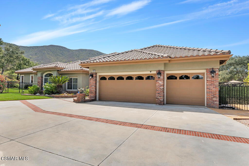 This private, single-story estate in Newbury Park offers a rare blend of timeless design, natural beauty, and lifestyle flexibility-set on over three-quarters of an acre. Tucked behind a long private drive with potential for gated access, this 4,417 sq ft residence delivers expansive single-level living, indoor-outdoor flow, and stunning mountain views.The backyard is a true retreat, backing to open space with multiple patios, a sparkling pool and spa, and a 740 sq ft covered pavilion with fireplace, TV hookups, and built-in outdoor kitchen. Fruit trees, garden beds, and mature landscaping complete the experience.Inside, wide-plank hardwood and slate tile floors connect generous living and dining spaces. The kitchen offers ample storage, a large granite island, built-in refrigerator, double ovens, and a five-burner gas range-ready to be personalized by the next owner. A full laundry room, mudroom, and an entertainer's bar with passthrough window offer practical everyday function.Custom 16-foot lift-and-slide doors open completely to the backyard, blending the interior with nature. The layout includes a guest/in-law suite with separate entrance, all en-suite bedrooms, and a spacious primary retreat. The oversized lot also offers room for a future ADU.Energy-efficient and safety-minded, the home includes solar with two Tesla Powerwall 3 units, ember-resistant roof and vents, a dedicated fire gel pump system, dual Navien tankless water heaters, fiber internet, and fresh interior/exterior paint.Motivated sellers have thoughtfully repositioned this offering to create opportunity. A rare single-level estate with exceptional privacy, just minutes from trails, open space, and the 101.