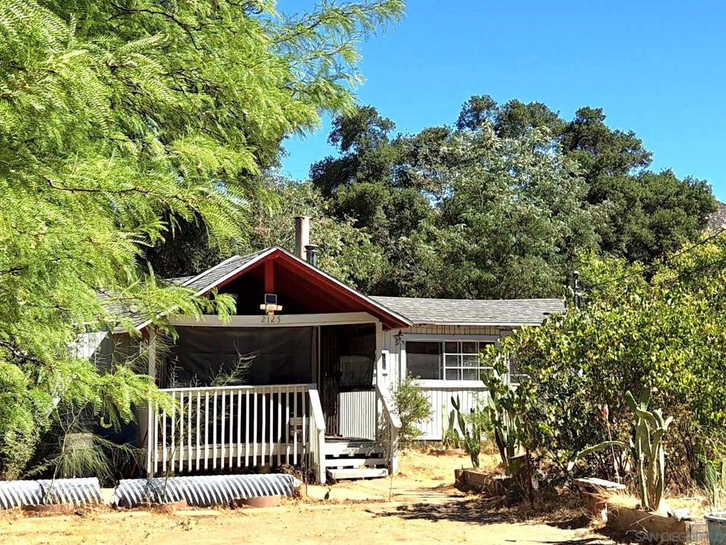 Country feel in Campo. The best priced property around. Owner may carry with 150k down. Cozy house with a nice, covered porch to sit in the shade of the oak and mesquite trees. Private drive, relax and enjoy your 3 acres. 2 large bedrooms, one full bath, bonus rooms, covered shop area off the back. One of the original cabins in the area, house has been added onto that over the years. Rock fireplace with woodstove in kitchen area. Excellent ranch potential etc. Well is exceptional. Lots of water for irrigation. Bring an offer!!!
