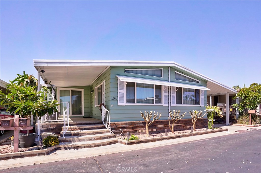 It is located on one of the Cul-De-Sac locations, across from the large guest parking island. Spacious floor plans in Anaheim Shore Estate with 3 bedrooms, 2 baths, a Triple-Wide Home are located in the Prestigious Anaheim Shores Estates. This family park has large green belts and wider streets. The clubhouse amenities include a pool, spa, clubhouse with kitchen, card room, billiard room, multipurpose room, BBQ, and covered picnic area. The formal living room and formal dining room have beamed vaulted ceilings. A portion of the family room was used to create a 3rd bedroom with a mirrored closet door, a ceiling fan, and a slider to the front porch. This room is perfect for a den/office. The kitchen has been completely updated with Corian countertops and raised height cabinets/countertops and with dual sinks. The guest bedroom has mirrored closet doors and a ceiling fan. The master bedroom is enormous, has a ceiling fan, and a slider to the covered patio. The master bath has been completely remodeled, with a walk-in closet, a Roman-style tub, and a separate, unique stall shower. All windows and sliders are dual-pane—many more upgrades.
Refrigerator, washer, and dryer included. Centrally located to the 91 and 5 Freeways!