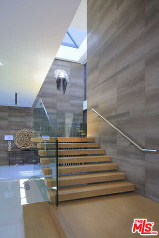 Overlooking the prestigious Bel Air Golf Course with jetliner views from Downtown to The Getty and Pacific Ocean, this just completed architectural home in Bel Air is nestled at the end of a quiet road on a spectacular promontory totaling over one acre. Set behind gates, the home features 24-foot ceilings and automatic Fleetwood glass walls that blur the line between indoors and out. Amenities include a soaring great room, den, 500-gallon saltwater aquarium, chef-caliber kitchen, cigar room, theater, maid's quarters and cabana room. Upstairs holds an approx 2,200 SF master suite with a bar, sitting room, dual baths, showroom closets, an approx 800 SF outdoor lounge with city-to-ocean views. Two ensuite bedrooms boast unobstructed views, while an ultra-private VIP suite offers its own terrace. A park-like yard features a sprawling lawn and 62-foot infinity pool. Complete with Control 4 automation, this home represents the highest caliber of living in L.A.'s most coveted neighborhood.