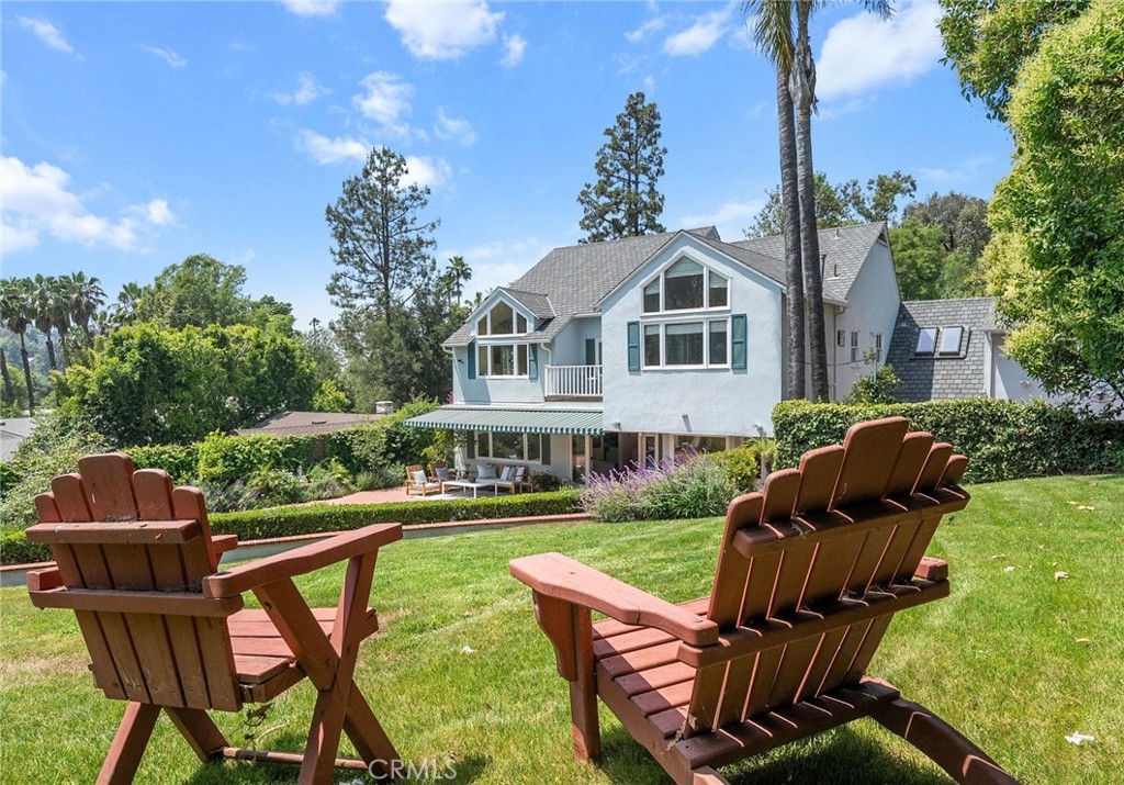 Tucked away in the hills of Studio City at the end of a secluded cul-de-sac, this gated celebrity compound sits on a sprawling 13,000+ sf lot that offers complete privacy and breathtaking views. Featured in numerous publications, this enchanting 1940s Cape Cod estate – complete with a separate guest house – has been beautifully updated throughout, thoughtfully blending timeless charm with modern amenities. The bright and airy main level welcomes you with a spacious open-concept formal living and dining room that flows seamlessly into an inviting family room, here double French doors open for indoor-outdoor living and entertaining. A culinary enthusiast's dream, the designer chef's kitchen is equipped with top-of-the-line Viking appliances, granite countertops and a sun-drenched breakfast nook. Upstairs, you'll find four generously sized bedrooms, including two with vaulted ceilings and oversized windows that perfectly frame the picturesque vistas. One of the bedrooms boasts a loft space, while the other has access to a private balcony. The expansive primary suite serves as a private sanctuary, featuring stunning views, a cozy fireplace, dual walk-in closets with custom built-ins and a spa-inspired ensuite bathroom, complete with a clawfoot soaking tub that's bathed in natural light from two skylights above, a rainfall shower and double vanity. Designed for privacy, the serene backyard is enveloped by lush mature landscaping and boasts no visible neighbors or overhead utility wires. This park-like retreat is highlighted by a sparkling PebbleTec pool, built-in spa and outdoor speakers. The guest house, with its own private entrance from the street, offers a kitchenette and full bathroom – a perfect setup for extended family, guests or rental income opportunities. Additional amenities include a large office with a private entrance, a laundry room, security system, gated driveway and two-car garage with a Tesla supercharger. Ideally located South of the Boulevard in the exclusive Fryman Canyon Estates (a fire-wise community with access to deep discounts for fire insurance), this exceptional property lies within the coveted Carpenter School District and is just moments away from trendy restaurants, boutique shops, Fryman Canyon hiking trails and so much more.