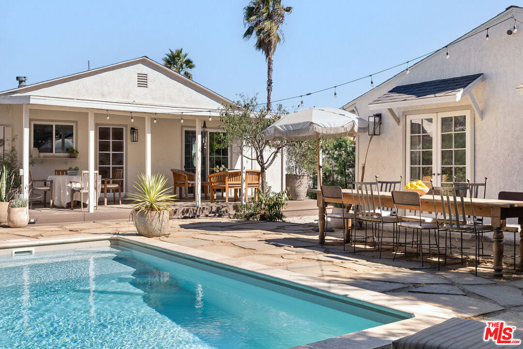 Tucked behind a tree-lined fence, this renovated one-story bungalow offers the perfect private oasis to call home. The owners have thoughtfully updated the property with expert craftsmanship, incorporating details like Zia tile and marble sinks, all intended to enhance the home's original charm. From the inviting front porch to the bookshelf-filled reading nook off the dining area, every corner of this residence feels warm and welcoming.Inside, beautiful hardwood floors and a quaint fireplace anchor the living room, while the newly remodeled kitchen features modern appliances, a built-in coffee bar with a beverage fridge, and timeless finishes. The main house boasts three bedrooms, one of which has been set up as an office with direct access to the outdoor back deck.The backyard is a true retreat, complete with a pool and a separate guest house. The guest house offers a full one-bedroom suite with its own kitchen, laundry, and bathroom, providing endless possibilities for hosting visitors, accommodating extended family, or creating a private workspace.With its balance of updated amenities and enduring character, this home is as comfortable as it is stylish. Conveniently located three blocks from the new NOHO West development and just minutes from the NoHo Arts District, Valley Village, Studio City, and Toluca Lake.