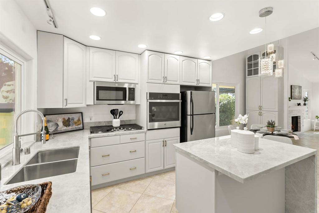 Disclaimer: we cannot be held responsible if your guests become jealous when they see how nice your home is! As soon as you walk through the front door you are greeted with high ceilings and an open floor plan that connects the warm and spacious living room to the designer kitchen. This stunning townhome features REAL Taj Mahal Quartzite in the kitchen and bathroom countertops, a natural and extremely durable stone that is only typically found in multimillion dollar homes. You also have REAL marble tile from the floor to the ceiling in both bathrooms and around the fireplace in the living room. Floors are a timeless porcelain tile imported from Italy, and the bedrooms feature a high quality and super soft carpet. Additional upgrades include new top of the line stainless GE appliances, advanced Samsung all-in-one washer/dryer machine in the laundry room, new lighting and plumbing fixtures throughout, new high efficiency water heater, new epoxy garage floors, advanced Lutron dimmable lighting system that can adjust not only the brightness of the lights throughout the home but also the color of the lights. Home also features full home air conditioning with Nest thermostat, private patio off the kitchen and primary bedroom and a large and private deck off the living room. Large primary bedroom features 2 separate closets, large bathroom with walk-in shower. Secondary bedroom is generous in size and secondary bathroom features new soaking tub. Community features only 48 units in the peaceful complex, low HOA fees, pool/spa and weekly landscaping. Location is excellent! Home is in walking distance to great schools, groceries, major freeways and public transportation, hospitals and Cal State San Marcos University. Don't miss this amazing opportunity to have all the luxury designer features that you have always dreamed of!