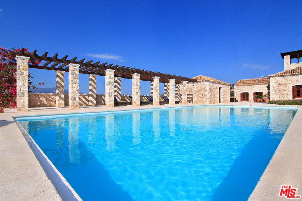 This stone mansion villa is located in a quiet neighborhood of incredible beauty and gives the opportunity to the guest to enjoy endless sea views and colorful wildflowers carpeting the earth, in one of the last-remaining, unspoiled hideaways of pure nature. The residence provides an immediate path through the garden to a stunning, secluded beach, with crystal-clear waters and a private dock. This residence has a wonderful orientation, since the sun sets right in front of the house and one can enjoy that view from every corner of the house. Its architecture comes from the French countryside and it combines also some beautiful Greek elements. The villa is elegantly decorated in a unique manner, while it keeps a special and refined character. Floor-to-ceiling windows open to large verandas and outdoor lounge areas, providing breathtaking views of the sea, while the colors of the sky dance playfully from dawn to dusk. Elope to the belvedere tower and enjoy the sunset, through captivating panoramic views of the surrounding coves. Treat yourself to delicious meals with fresh, raw ingredients from the property's organic garden. Renew yourself in this rural retreat of understated luxury and connect with nature unbroken. Accommodation: Upper Level Belvedere tower with 360 panoramic views. 15x7.5 m swimming pool with outdoor sun beds and lounge areas. Master Bungalow en-suite bathroom. Pool House Bungalow en- suite bathroom. Main House 2 bedrooms | 2 Independent Bathrooms | Hall | Living Room |Dining Area | Kitchen Garden Level | 2 Bedrooms | 2 Independent Bathrooms | 2-Bedroom Suite with one bathroom | Kitchenette
