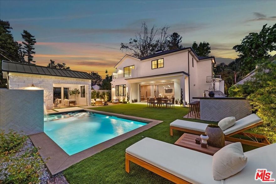 Spectacular custom-built home situated within the highly desirable area of studio city. Boasting 5BD/6.5BA this home has been meticulously designed to perfection and built with only the finest of finishes. Upon entering you'll be greeted by seamless oak flooring and an abundance of natural light. The chef's kitchen is a culinary masterpiece featuring a generously sized island, white oak cabinetry, glistening calacatta countertops, Thermador appliances, walk-in pantry, and a seamless connection to the living room. The expansive living room showcases a marble  custom arched built-ins, and aluminum pocket doors that open up to the resort-like backyard, creating a seamless indoor-outdoor lifestyle. On the lower level there is an ensuite guest bedroom as well as a powder room for added convenience. Upstairs the exquisite master suite serves as a peaceful oasis with a cozy fireplace, a large walk-in closet, and balcony overlooking the backyard. The opulent master bath resembles a spa retreat with its soaking tub, shower, dual vanities with travertine stone. Additionally there are three more ensuite bedrooms upstairs along with a laundry room. The expansive backyard is surrounded by beautiful landscaping, tall fence ensuring privacy, and features a refreshing pool/spa and ample space for entertaining.  Great pool house that feature a gym and amazing basketball court, as well firepit area and outdoor kitchen. Nestled within the highly sought-after tujunga village neighborhood. welcome!