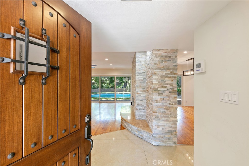 Welcome to this beautifully remodeled gem in the heart of North Hills! This thoughtfully upgraded home offers 3 spacious bedrooms, 2 modern bathrooms, and over 1,800 square feet of comfortable living space, all set on a generous 8,094-square-foot lot. Step inside to discover real hardwood and tile flooring throughout, copper plumbing, fresh interior paint, and elegantly updated bathrooms. The inviting living room features a striking StackStone fireplace perfect for cozy nights in. At the heart of the home is the chef’s kitchen, showcasing rich wood cabinetry, sleek quartz countertops, a large waterfall island, a newer cooktop, and a stylish vent hood ideal for both everyday cooking and entertaining. The primary suite features a spacious walk-in closet with custom-built-in storage for maximum organization. Outside, the backyard is an entertainer’s paradise, featuring a large covered patio, built-in BBQ bar, and a lush grassy area perfect for kids and pets. Enjoy year-round relaxation in the brand-new smart heated pool and jacuzzi, easily controlled from your smartphone. The fully finished, attached two-car garage offers versatility with vinyl flooring, insulated drywall, and a mini-split AC and heating system, making it ideal for use as a gym, studio, or workshop. A brand-new paverstone driveway provides ample parking for multiple vehicles. Centrally located near shopping, dining, and major freeways, this move-in-ready home has it all. Don’t miss out on this great property!