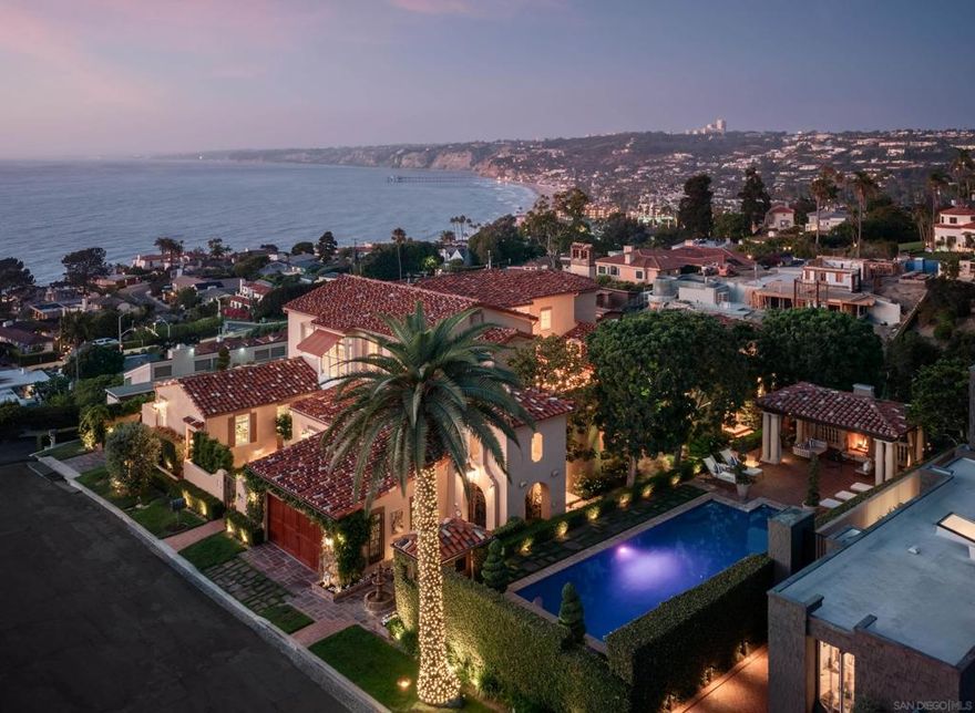 Casa De La Vista is a rare Spanish Colonial Revival estate set above La Jolla, offering sweeping views of La Jolla Cove, Scripps Pier, and the Pacific. Set on three-quarters of an acre with lush grounds, this 8,347 SF residence features six bedrooms, six full bathrooms (five ensuite), two half baths across three levels. Built in the 1920s and believed to be one of the earliest homes completed in the area, Casa De La Vista is steeped in Olde La Jolla history and offers an unparalleled blend of old-world elegance, privacy, and coastal splendor. Beyond its private entry gate at the end of a cul-de-sac, the home unfolds across terraced gardens, multiple patios, a tranquil interior courtyard, and lush landscaping, all overlooking one of La Jolla’s most breathtaking coastal outlooks. Vibrant Spanish detailing and hand-painted artisan tiles in the style of San Miguel de Allende speak to the property’s rich heritage, while expansive windows frame uninterrupted views of the ocean and surrounding treetops. This legacy estate blends timeless elegance with an unmatched location, just moments from La Jolla Village, world-class beaches, dining, and acclaimed public and private schools. With La Jolla, the jewel of Southern California, as its setting, Casa De La Vista captures the essence of effortless coastal living.  {Supplement} Casa De La Vista, at 7757 Whitefield Pl, is a rare architectural gem with 8,347 square feet of tasteful living space set on three-quarters of an acre of lush grounds. It features six bedrooms, six full bathrooms (five of which are ensuite), and two half baths, thoughtfully arranged across three expansive levels. This exceptional Spanish Colonial Revival estate is situated on the coveted mountainside of La Jolla, poised for commanding, panoramic views of La Jolla Cove, Scripps Pier, and the shimmering Pacific Ocean.  Built in the 1920s and believed to be one of the earliest homes completed in the area, Casa De La Vista is steeped in Olde La Jolla history and offers an unparalleled blend of old-world elegance, privacy, and coastal splendor. Beyond its private entry gate at the end of a cul-de-sac, the home unfolds across terraced gardens, multiple patios, a tranquil interior courtyard, and lush landscaping, all overlooking one of La Jolla’s most breathtaking coastal outlooks. Vibrant Spanish detailing and hand-painted artisan tiles in the style of San Miguel de Allende speak to the property’s rich heritage, while expansive windows frame uninterrupted views of the ocean and surrounding treetops.  The heart of the home is the dramatic main living area, anchored by a fireplace, with 22-foot vaulted ceilings, exposed wood beams, and seamless transitions to outdoor living. The chef’s kitchen, bright and inviting, flows naturally into both formal and informal spaces, perfect for entertaining against the backdrop of sunset-drenched skies and open ocean.  The primary suite is a sanctuary of its own, featuring sweeping views, an ornate marble bathroom, an expansive walk-in closet, and direct access to the interior courtyard. Throughout the home, original details blend beautifully with modern comforts, creating a space that feels both contemporary and timeless.  Various charming outdoor spaces lend warmth and coziness, including a resort-style pool terrace, multiple patios, and a serene interior courtyard with stone fireplace, ideal for relaxing and entertaining. Two guest houses offer privacy and flexibility, while additional amenities include a private gym, home office, and two 2-car garages.  Just moments from La Jolla Village, La Jolla Heights Nature Park, and the La Jolla Beach and Tennis Club, this premier location offers fine dining, luxury shopping, acclaimed schools, golf, hiking, and some of the region’s best beaches. With La Jolla, the jewel of Southern California, as its setting, Casa De La Vista captures the essence of effortless coastal living.