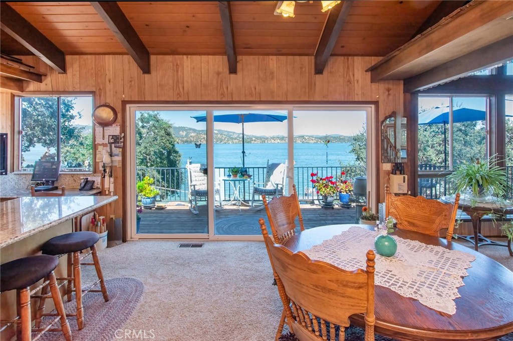 A MUST SEE LAKEFRONT ESTATE with guest/in-law quarters, private boat house, lake rights, and SOLAR! This home was custom built and has been well taken care of ever since. On the main level you will be welcomed by an open-concept kitchen and living room with a beautifully crafted wood burning fireplace, and floor-to-ceiling windows showcasing unobstructed views of Clear Lake. The kitchen features granite countertops, and a large island with an eat-in-area. With two large living room areas on the main level, the opportunities are endless, with space for a gameroom, bar, home theater, or massive primary suite. The home features an attached wrap-around deck showcasing lake views from almost every corner and peek-a-boo views of Konocti Harbor Resort. On the main level you will find 2 bedrooms both with vaulted ceilings and their own full bathrooms. On the lower level, accessible from the interior of the home or by a separate entrance, you will find what has most recently been used as a separate living quarters with 1 large bedroom, its own living room, an oversized full bathroom with jacuzzi style tub, walk-in closet, separate washer & dryer, and kitchenette. On this level you will also find additional storage and your own private garden and patio area. This estate features a detached two car garage with extra storage and a washer & dryer. Just steps away from the home you will discover a private dock, boat house & launch, gazebo, and direct access to the lake. A new roof and water heater were installed in 2023! This property provides almost 4 acres of usable land ready for an additional dwelling, vineyard or large garden and has no HOA restrictions. Located minutes away from local wineries, shopping, and Buckingham Golf & Country Club, and only an hour from Calistoga, Napa and more!