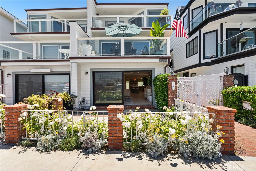 Nestled on the coveted Balboa Peninsula, this completely renovated two-story condominium offers refined bayfront living with stunning design and top-tier finishes throughout. Fully furnished and detailed to perfection, this move-in-ready home blends modern luxury with timeless coastal style.
Step inside the ground-level entry to discover an open, airy layout that captures sparkling bay views through expansive glass sliding doors in the living room and kitchen. A striking see-through fireplace clad in natural coral tile elegantly separates the living and dining areas, creating a warm and sophisticated gathering space.
The reimagined kitchen has been thoughtfully expanded and features custom white oak cabinetry, luxurious Italian Calacatta Venato slab countertops, generous countertop seating, and ample storage. High-end appliances, including a Sub-Zero refrigerator and Fisher & Paykel range and oven, complete this chef’s dream kitchen.
A stylish powder room showcases a Taj Mahal quartzite countertop, brushed gold faucet, and Walker Zanger tiled backsplash for a designer touch.
Upstairs, a wool-lined carpet staircase leads to a convenient laundry alcove with Whirlpool washer and dryer, custom white oak cabinets, and elegant Walker Zanger tile. The primary suite is a private sanctuary featuring built-in closet organizers and a spa-inspired en-suite bath with a freestanding tub, dual vanity with Italian Carrara marble countertops, brass sinks, and a striking black industrial shower door with bush-hammered herringbone marble tile and marble bench. Designer details like Walker Zanger flooring, Brizo plumbing fixtures, and Hudson Valley pendant lighting elevate every inch of this retreat.
The secondary bedroom offers a built-in closet organizer and an adjacent guest bathroom finished with an oversized sink, Brizo fixtures, a combed limestone backsplash, alabaster sconces, Walker Zanger ceramic shower tile, and Italian flooring.
Additional highlights include a private in-ground built-in spa on the second patio, motorized window treatments throughout, and a convenient two-car tandem garage.
With bay views from the main living areas and all the best of the Peninsula just steps away, 1817 W. Bay Avenue Unit A is your opportunity to experience the ultimate Newport Beach lifestyle.