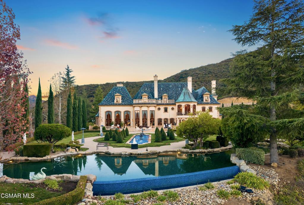 Chateau Plaisance, a CASTLE nestled within the prestigious 24/7 guard gated Sherwood Country Club, spans nearly 3 private acres across 5 lots, offering breathtaking views of the spectacular Santa Monica Mountains and the renowned Jack Nicklaus Signature Golf Course. Perfected in every detail, this approx. 14,113-square-foot French-inspired masterpiece showcases unparalleled artisanship and timeless elegance.The Castle's park-like grounds are a true masterpiece, featuring formal box-hedged gardens filled with thousands of roses, lush lawns adorned with life-sized statuary, and cobblestone pathways leading to a striking 52-foot reflection pond where bronze horses appear to gallop through cascading water. A serene large infinity pool and spa with a waterfall, a koi pond, and an ornate iron gazebo overlooking the valley complete this enchanting outdoor retreat.A grand entrance welcomes you into the rotunda, where a dazzling Baccarat chandelier, hand-painted murals, and a sweeping marble staircase with a gold-leafed iron banister set the tone for the opulence within. The 22-foot-high Grand Salon & Ballroom boasts two Spanish brass and crystal chandeliers, a carved fireplace, and towering windows that frame the gardens. An elevated alcove provides the perfect stage for entertainment.The richly paneled library, complete with parquet flooring, a fireplace, and a hidden bar, offers a cozy escape, while the formal dining room, seating 20, is illuminated by two custom Waterford chandeliers. The gourmet kitchen, adorned with antiqued cabinetry, parquet flooring, four subzero refrigerators, and two oversized islands, opens to a warm and inviting family room featuring a grand fireplace, elegant window seating, and a granite-topped bar.The second floor offers a luxurious primary suite with a sitting area, fireplace, a sleek wet bar, and two lavish spa-inspired baths with oversized closets. Additional guest suites, a Carriage House apartment, and a hidden third-floor bonus space provide ample accommodations. The completed third floor features four separate rooms, providing endless possibilities for a home theater, gym, art studio, or private retreat.This Castle also includes a Pool House--a Mini Chateau with a great room, grand fireplace, kitchen, and two bathrooms, perfect for poolside entertaining. Two gated entrances lead to an elegant courtyard with an imported French fountain, while a separate guest parking area and the Grand Plaza can accommodate up to 150 guests.Gated guest parking is conveniently located near the charming greenhouse and the elegant archway leading to the Grand Plaza, designed to accommodate approximately 150 guests with ease. Chateau Plaisance Castle stands as a pinnacle of luxury, privacy, and grandeur--an estate unlike any other to ever grace the market.