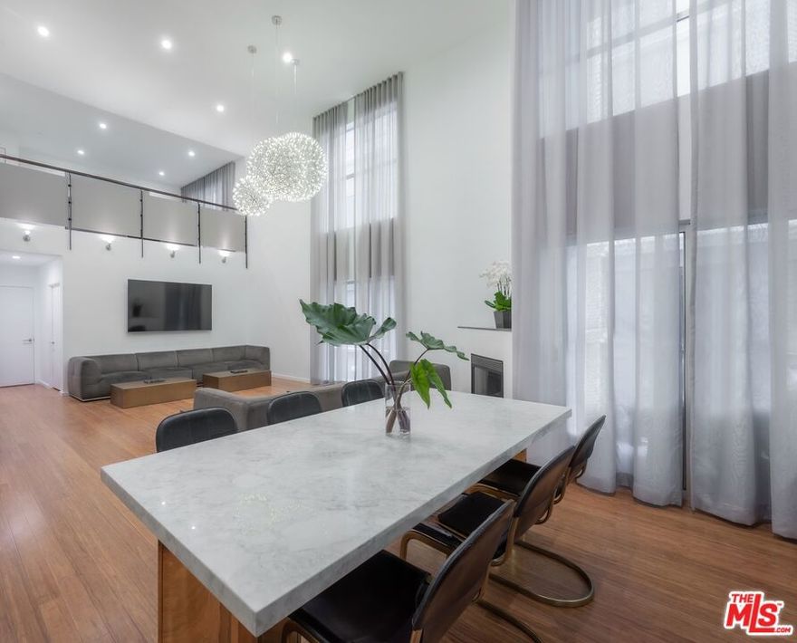 Luxurious designer-furnished loft in the heart of Hollywood offering an expansive open layout with soaring ceilings, abundant natural light, and dramatic walls of glass. This 2 bed / 2 bath home features marble bathrooms, a statement gas fireplace, in-unit laundry, and elegant finishes throughout. Two parking spaces, controlled access, and rooftop deck are included. Walkable to premier dining, shopping, nightlife, and transit