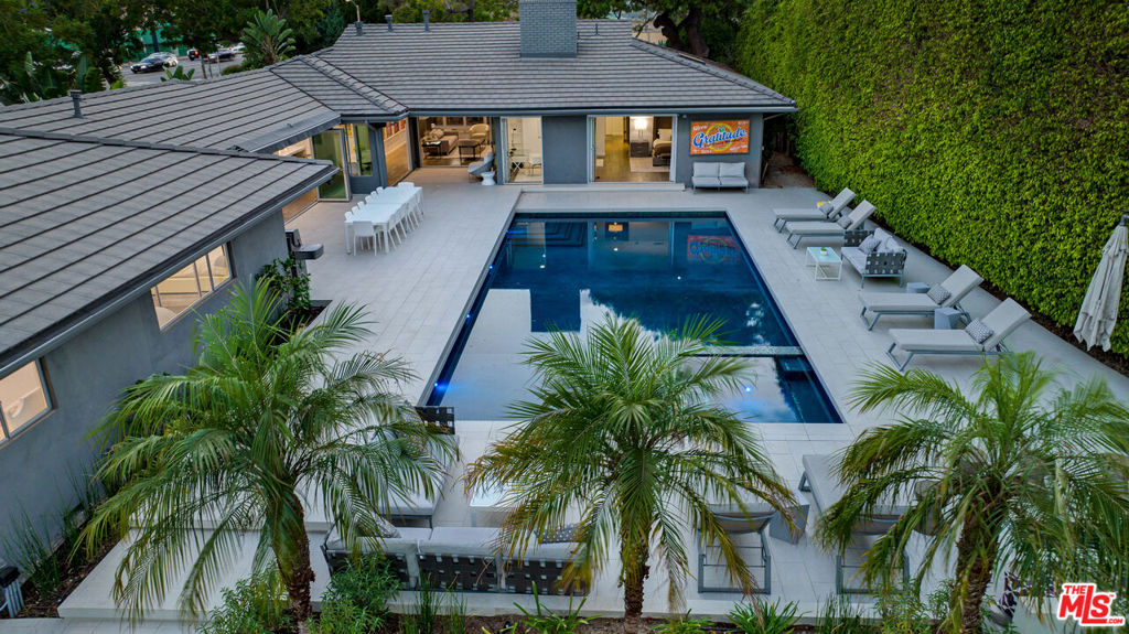 FULLY FURNISHED. PICKLEBALL COURT, BASKETBALL, PILATES REFORMER, GYM. 2 CAR GARAGE PLUS 5 CAR DRIVEWAY PARKING, EV CHARGER. POOL HAS A RETRACTABLE COVER. GATED. PRIVATE. The pinnacle of California living in this stunning single-story contemporary estate nestled in the prestigious Beverly Hills Flats. Designed with an emphasis on seamless indoor-outdoor flow, this fully remodeled residence features an open-concept floor plan flooded with natural light and curated with designer finishes throughout. The expansive living spaces boast wide plank wood floors, floor-to-ceiling sliders, and iconic pop art, creating a perfect harmony of sophistication and style. The gourmet kitchen opens to multiple entertaining areas, ideal for both intimate gatherings and large-scale entertaining.Step outside to your private oasis a resort-style backyard complete with a sparkling pool, spa, lounge areas, built-in BBQ, and al fresco dining under the stars. Surrounded by lush landscaping and tall privacy hedges, this home offers tranquility just moments from world-class dining, shopping, and entertainment. This turnkey estate is the ultimate expression of modern luxury and relaxed elegance in one of L.A.'s most coveted neighborhoods.