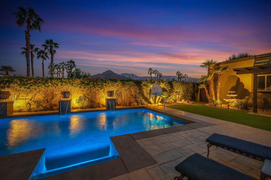 Discover the perfect balance of tranquility and sophistication in this beautifully updated and meticulously maintained 4-bedroom, 4.5 bath retreat, ideally nestled on a quiet, private corner lot in the exclusive Painted Cove community of South La Quinta. Step through impressive custom doors into a serene great room where soaring ceilings, a cozy fireplace, and unobstructed south-facing mountain views create an atmosphere of calm and natural beauty. Expansive walls of glass bathe the home in soft desert light, framing the stunning vistas and seamlessly connecting the interiors with peaceful outdoor living spaces. The luxurious primary suite is a private sanctuary featuring its own fireplace, dual spa-style bathrooms, a soaking tub, and a bonus closet/spa area--perfect for unwinding in total comfort. Two ensuite guest rooms offer privacy and relaxation for visitors, while the fourth bedroom serves as a fully equipped media room for cozy movie nights or game-day gatherings. Designed for effortless entertaining, the home showcases a sit-down bar, an elegant formal dining room with a built-in wine refrigerator, and a gourmet kitchen with a spacious center island and walk-in pantry--ideal for hosting everything from intimate dinners to lively celebrations. Step outside to your private resort oasis, where a covered patio, fire table, BBQ area, and lush, artfully lit landscaping set the stage for effortless indoor-outdoor living. The updated saltwater pool and spa, complete with tranquil water features, invite you to relax and recharge in total privacy, surrounded by peaceful mountain views. Additional highlights include a whole-home and outdoor speaker system, and a three-car garage. Built by renowned builder Peter Ministrelli, this 3,774 sq. ft. residence embodies refined desert living--quiet, private, and beautifully designed for both relaxation and celebration. Located just minutes from La Quinta's premier golf courses, fine dining, boutique shopping, and the Indian Wells Tennis Garden, it offers a lifestyle of peace, privacy, and luxury. A true sanctuary for the soul--and the perfect home for entertaining. Offered turnkey furnished.