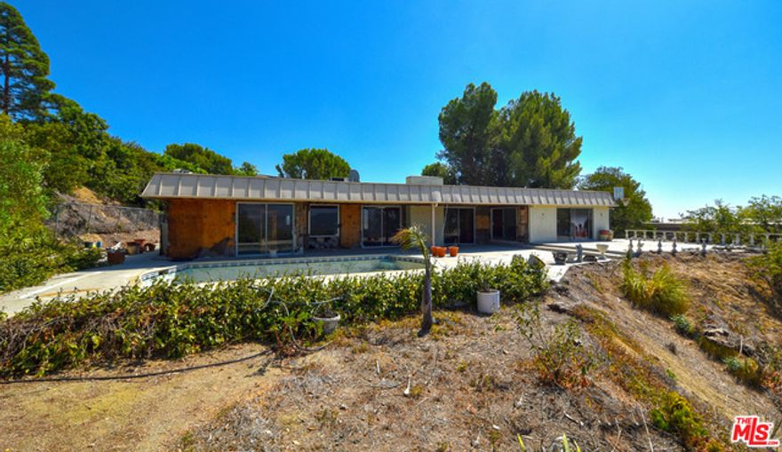 Prime Trousdale Estates in Beverly Hills! 3 bed/4.5 bath Hollywood Regency in the spirit of John Elgin Woolf, on 25K plus sqft lot w/beautiful VIEWS. In a quiet, residential area is this gated property ready for a makeover or new construction.  Bring your imagination & contractor to build/remodel into a fabulous home. A few short minutes to schools, shops, restaurants, public transportation. Buyer must independently investigate + confirm all property details to their satisfaction. Property is sold AS-IS.  Owner may carry in 1st position.  Please call LA1 for details.