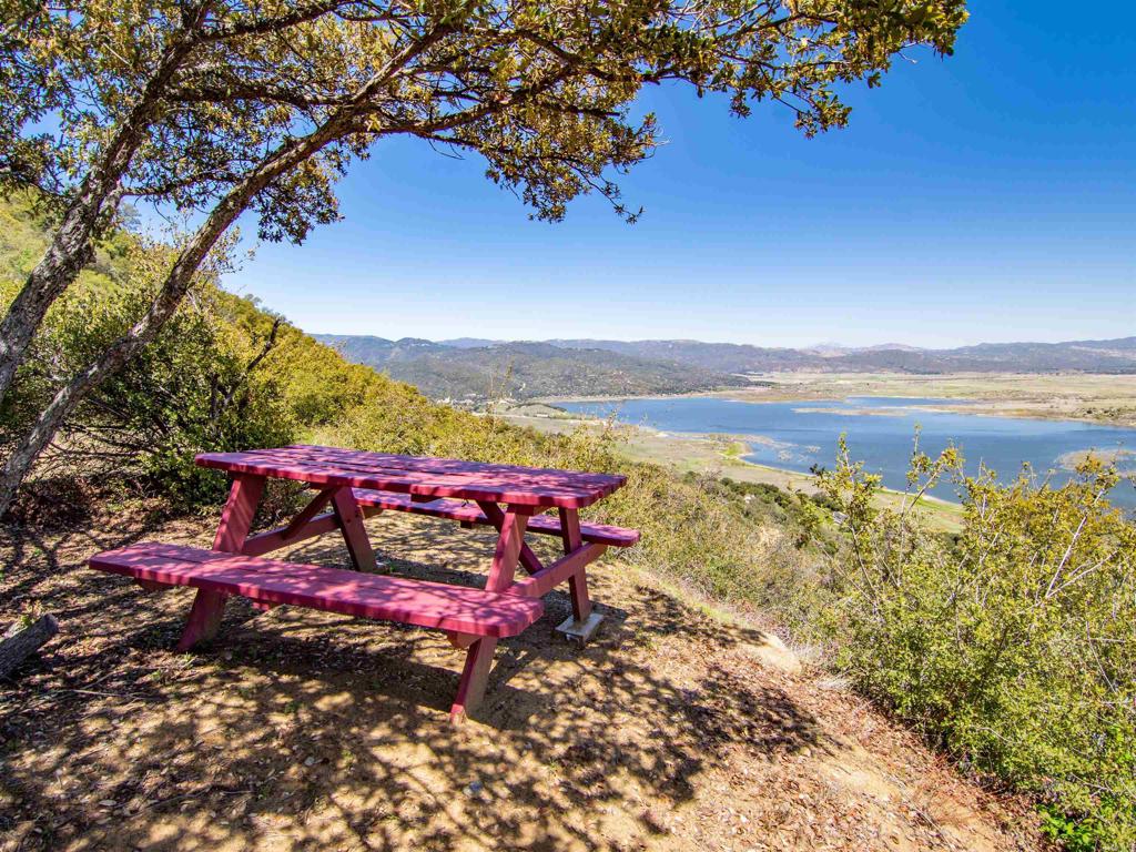 Discover the epitome of natural beauty at this breathtaking 17+/- acre property located on Bobcat Trail in the heart of Mesa Grande. Perched above Lake Henshaw, this scenic parcel offers sweeping, unobstructed views across a quiet, undeveloped valley that comes alive with seasonal wildflowers and shifting color throughout the year. A series of thoughtfully graded pads offer versatile spaces to enjoy the landscape—ideal for camping, recreational use, or simply soaking in the panoramic vistas from different elevations. With varied terrain, native vegetation, and a peaceful setting, the property invites exploration and quiet appreciation of the surrounding wilderness. Located at the end of a country road, this retreat offers a rare sense of privacy and seclusion, yet remains close to a wealth of regional amenities. The surrounding area is rich with opportunities for hiking, biking, wildlife observation, and stargazing, while nearby Lake Henshaw provides fishing and water recreation. Enjoy local wineries, charming eateries, and cultural landmarks in nearby Santa Ysabel and Julian. Whether you're seeking a serene getaway, a base for adventure, or a connection to San Diego County’s untouched backcountry, this property offers an inspiring setting that feels a world apart.