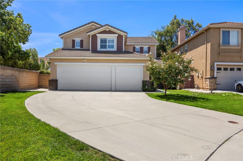 Set on a quiet street in Chino Hills, this 5-bedroom, 3-bathroom residence offers a peaceful retreat with generous living space and thoughtful upgrades. Built in 1999 and featuring an attached three-car garage, this home blends comfort, style, and convenience in one inviting package. Step through the front door into a soaring living room where extra-high ceilings create an airy, open ambiance. Rich wood flooring stretches across most of the main level, setting a warm and elegant tone from the moment you arrive. Just beyond the living room, the dining area provides a seamless transition between spaces—perfect for hosting intimate dinners or lively gatherings. Its proximity to both the kitchen and living room makes entertaining effortless. The kitchen is a true centerpiece, boasting generous cabinetry, gleaming stainless steel appliances, and a substantial island ideal for meal prep or casual dining. Granite countertops add a touch of sophistication, while the layout ensures both functionality and flow. Adjacent to the kitchen, the family room invites relaxation with its cozy fireplace and expansive windows that frame serene views of the backyard. Whether you're enjoying a quiet evening or entertaining guests, this space offers comfort and charm. Tucked away on the main floor is a convenient guest bedroom located next to a full bathroom with a walk-in shower—perfect for guests or multi-generational living. Upstairs, you'll find three additional guest bedrooms. These rooms share a beautifully maintained full bathroom, designed to accommodate both family and visitors with ease. The primary suite is a private retreat, entered through elegant double doors. A wall of windows bathes the room in sunlight, while the oversized walk-in closet provides abundant storage. The remodeled en-suite bathroom features a separate shower and a luxurious soaking tub—your personal spa experience at home. Throughout the home, you'll appreciate refined touches like bullnose corners, energy-efficient double pane windows, and custom shutters adorning most interior windows. Outside, a covered patio offers shade and comfort for outdoor dining or lounging, while the meticulously landscaped hill behind the home creates a natural barrier for added privacy and serenity. Located near award-winning schools, top-rated restaurants, and a variety of shopping destinations, this Chino Hills gem offers not just a beautiful home—but a lifestyle of convenience and community.