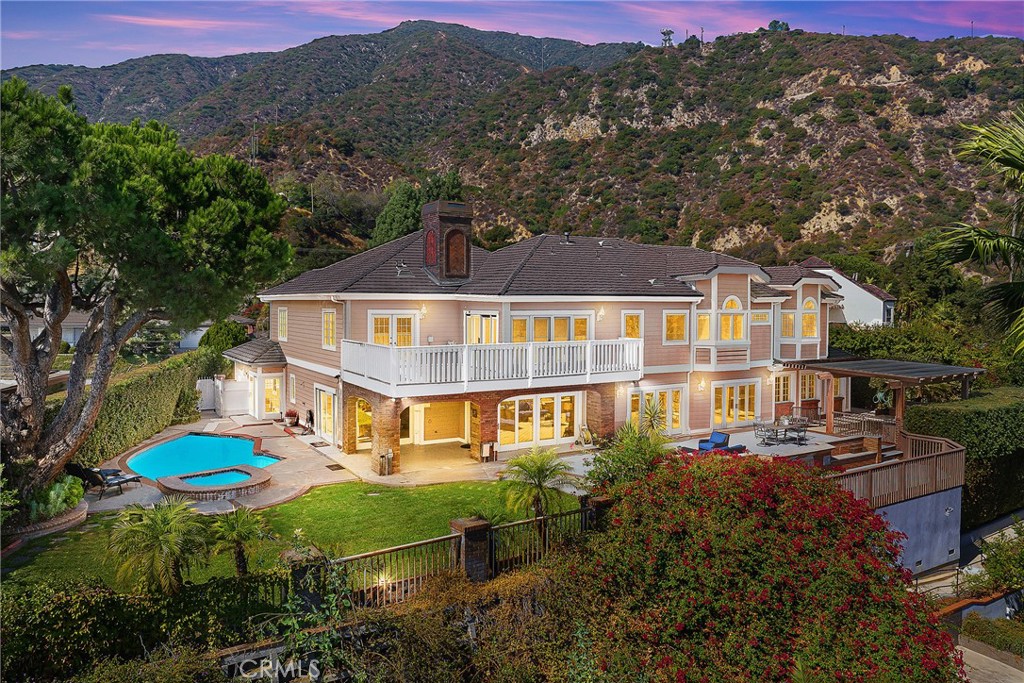 This spectacular view home, nestled in Arcadia's highly desirable Highland Oaks neighborhood, is part of the prestigious Arcadia School District and exemplifies Southern California living with expansive panoramic views of the gardens, mountains and city lights. Situated on a hilltop, this beautifully updated estate offers the perfect combination of serenity, breathtaking views and privacy. As you approach the home you're welcomed by a meticulously landscaped front yard and a paved circular driveway leading to an elegant entry. The artistry of marble inlay flooring graces the entry and living room, which seamlessly integrates indoor and outdoor spaces through walls of glass windows framing the stunning landscapes. The bright family room, with views of the pool and canyon, opens onto a large outdoor patio, perfect for entertaining. Anchored by two gas fireplaces, one in the living room and another in the family room, this home exudes warmth and comfort. The formal dining room and breakfast room, both featuring walls of glass, continue showcasing gorgeous scenic canyon views. Additional features include a large recreation room and beautiful wood floors throughout the living areas, enhancing the home's natural charm. Originally built in 1959 then rebuilt in 1991, this expansive 6,103 sq. ft. estate offers 8 bedrooms, 7.5 bathrooms, with 5 en-suite bedrooms upstairs and 1 en-suite downstairs. The primary suite elevates luxury with a fireplace, direct access to a sun-deck patio, two large walk-in closets, and a spa-like bathroom with a soaking tub offering incredible canyon views. The home is thoughtfully designed for entertaining and enjoying the surrounding garden and pool. Details like crown moldings, recessed lighting, elegant granite finishes, vaulted ceilings in the foyer and well-placed windows capturing sweeping views to include the surrounding beauty as part of the home’s interior demonstrate the attention to detail and design throughout the estate. The professionally landscaped backyard is an entertainer's dream, featuring two covered patios, a fully-equipped outdoor BBQ kitchen, ample decking, a lush lawn, and an inviting pool and spa. This tranquil outdoor space is perfect for leisurely afternoons, gardening, or simply enjoying the beauty of nature in a serene setting. This home truly epitomizes sophisticated California indoor/outdoor living. Be sure to take your time exploring this hilltop gem, a true retreat from the everyday hustle and bustle.