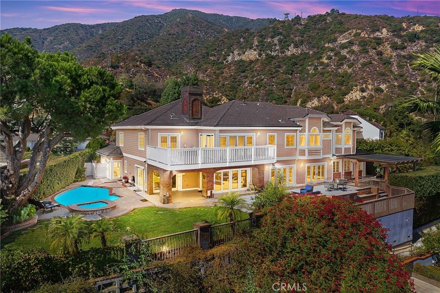 This spectacular view home, nestled in Arcadia's highly desirable Highland Oaks neighborhood, is part of the prestigious Arcadia School District and exemplifies Southern California living with expansive panoramic views of the gardens, mountains and city lights. Situated on a hilltop, this beautifully updated estate offers the perfect combination of serenity, breathtaking views and privacy.  As you approach the home you're welcomed by a meticulously landscaped front yard and a paved circular driveway leading to an elegant entry. The artistry of marble inlay flooring graces the entry and living room, which seamlessly integrates indoor and outdoor spaces through walls of glass windows framing the stunning landscapes. The bright family room, with views of the pool and canyon, opens onto a large outdoor patio, perfect for entertaining. Anchored by two gas fireplaces, one in the living room and another in the family room, this home exudes warmth and comfort. The formal dining room and breakfast room, both featuring walls of glass, continue showcasing gorgeous scenic canyon views.  Additional features include a large recreation room and beautiful wood floors throughout the living areas, enhancing the home's natural charm. Originally built in 1959 then rebuilt in 1991, this expansive 6,103 sq. ft. estate offers 8 bedrooms, 7.5 bathrooms, with 5 en-suite bedrooms upstairs and 1 en-suite downstairs. The primary suite elevates luxury with a fireplace, direct access to a sun-deck patio, two large walk-in closets, and a spa-like bathroom with a soaking tub offering incredible canyon views. The home is thoughtfully designed for entertaining and enjoying the surrounding garden and pool. Details like crown moldings, recessed lighting, elegant granite finishes, vaulted ceilings in the foyer and well-placed windows capturing sweeping views to include the surrounding beauty as part of the home’s interior demonstrate the attention to detail and design throughout the estate.  The professionally landscaped backyard is an entertainer's dream, featuring two covered patios, a fully-equipped outdoor BBQ kitchen, ample decking, a lush lawn, and an inviting pool and spa. This tranquil outdoor space is perfect for leisurely afternoons, gardening, or simply enjoying the beauty of nature in a serene setting. This home truly epitomizes sophisticated California indoor/outdoor living. Be sure to take your time exploring this hilltop gem, a true retreat from the everyday hustle and bustle.