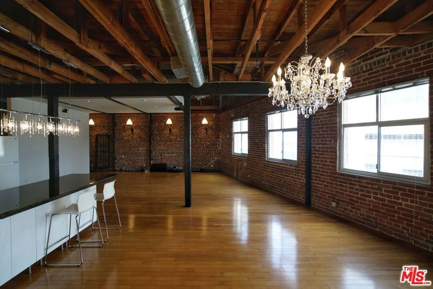 Rare Top-Floor Arts District Loft with Skyline Views & Same-Level Parking: Welcome to the pinnacle of Arts District living at 500 Molino. This stunning top-floor, two-level loft offers a massive 1,500 sq. ft. of open-concept living space, blending authentic industrial charm with modern luxury. The unit features soaring high ceilings, exposed brick walls, and custom hardwood floors, all illuminated by oversized windows that frame breathtaking views of the DTLA skyline. Unlike typical lofts, this unit offers superior privacy with only one small shared wall, ensuring a quiet sanctuary. It is an entertainer's dream, equipped with a 12-speaker surround sound system, dimmable lighting, and custom built-ins for ample storage. The chef-ready kitchen includes a dishwasher and built-in microwave, while the bathroom boasts a rain shower and jet bubble bath. Unique Convenience: Includes 1 assigned, gated parking space located on the same level as the unit no elevator required! Building amenities include a rooftop pool with BBQ, and a gym/fitness room and outdoor deck located directly across from the unit. Central A/C, heat, and in-unit washer/dryer included. Unbeatable location steps from Soho Warehouse, Bestia, Hauser & Wirth, and Little Tokyo.