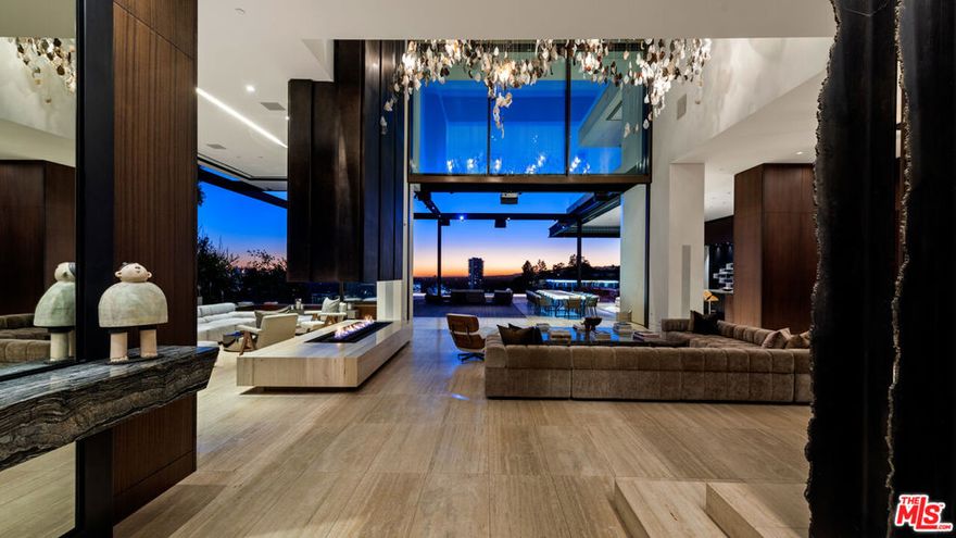 Nestled at the end of a cul-de-sac on one of the most sought-after streets in the Hollywood Hills, this sophisticated and modern home epitomizes luxury living. Encompassing an expansive 11,800 sqft of living space and surrounded by breathtaking views spanning from Downtown Los Angeles to the Pacific Ocean, the estate boasts 6 bedrooms, 8 bathrooms, and every world-class amenity desirable. Upon entry, the automatic retractable glass wall opens seamlessly and blurs the lines between indoor and outdoor living, creating the quintessential Southern California living experience. Just outside of the main living space is a vast deck adorned with an infinity-edge pool, spa, BBQ area, and multiple fire features. This deck offers an unparalleled setting for hosting events. Ascending to the second level, the primary bedroom displays unobstructed views, a private balcony, a spacious bathroom with a soaking tub, and dual walk-in closets. The lower level is a haven of wellness, boasting a fully equipped spa with a sauna encased in pink Himalayan salt walls, a media room, a bar, a wine cellar, and a cutting-edge fitness center. Completely controlled by Savant Technology, every aspect of the living experience is enhanced. The 20-foot, 3-car garage, equipped to accommodate 6 vehicles with a lift, adds a lavish touch to this unparalleled residence. Showings by appointment only. Also available for lease at $125,000.