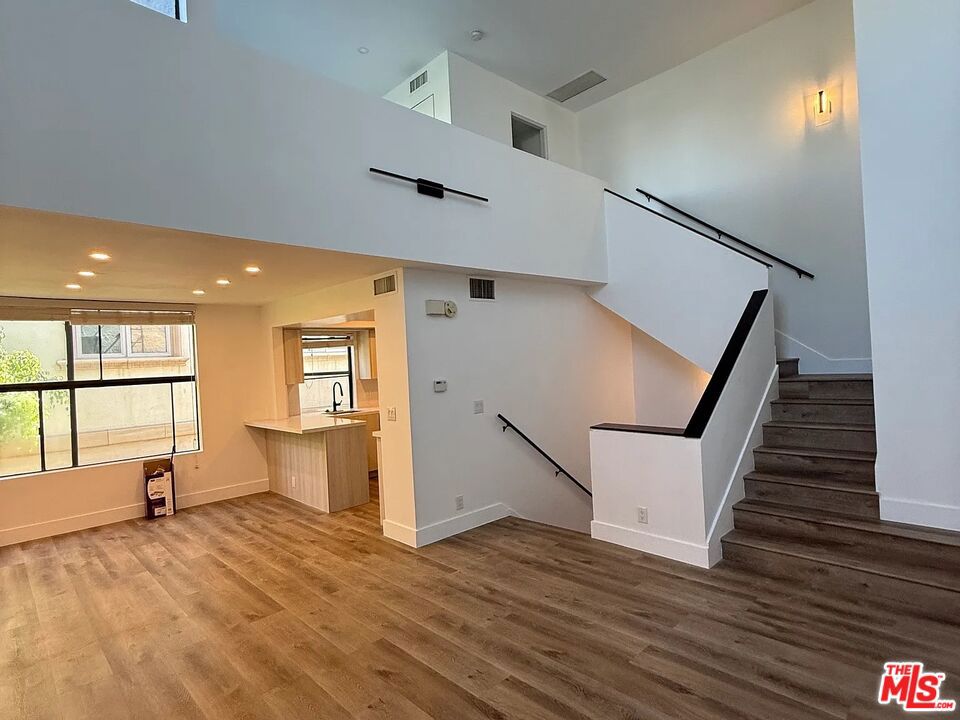 Welcome to this spacious three-level townhouse in the heart of Westwood. Featuring approximately 1,550 sq. ft. of living space, this 2-bedroom, 2-bath residence offers soaring ceilings, abundant natural light, and a modern open layout. The living area includes a cozy fireplace and access to a private balcony, perfect for relaxing or entertaining. The kitchen is appointed with stainless steel appliances, ample storage, and direct flow into the dining area. Upstairs, the primary suite boasts generous closet space and an en-suite bath, while the secondary bedroom provides flexibility for guests or a home office. Additional highlights include in-unit laundry, central air and heat, and two tandem parking spaces with EV charging. Set within a secure 8-unit building, this home offers both comfort and convenience with close proximity to UCLA, Century City, and the vibrant shops and dining of Westwood.