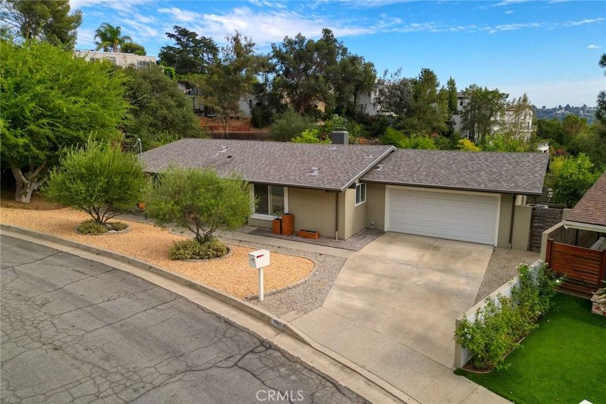 Mid-Century classic home in an idyllic, pastoral setting in the sought-after San Rafael Hills area of Pasadena.  Located on a tucked-away cul-de-sac, this home has been beautifully remodeled for both comfortable and gracious living.  Inside, the home enjoys beautiful wide plank flooring throughout.  The living room is fully open to both dining area and kitchen.  The light & bright living room enjoys vaulted ceilings oriented to the outdoors and anchored by a fireplace with stone surround and mantel.  Adjoining dining area features custom chandelier and sliding glass doors overlooking the patio.  The kitchen was lovingly remodeled by someone who loves to cook—and you can tell.  Beautiful white cabinetry, quartz clad countertops and backsplash, and stainless appliances, recessed and pendant lighting.  The bedroom wing includes 3 bedrooms and 2 redone bathrooms, including a master with private ¾ bath.  Outside, the patio is beautifully designed with a custom retractable awning for outdoor entertaining.   An attached 2 car garage has direct access.  The expansive grounds have been professionally designed and feel sculptural, with drought tolerant plantings and paths that invite you to meander throughout the yard.  This yard is framed by hillside, giving a feeling of complete privacy and serenity as you enjoy your new home.