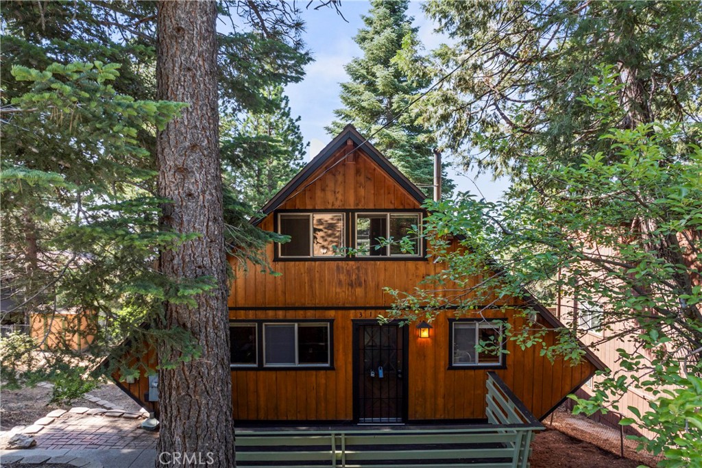 Welcome to your dream mountain sanctuary. This unique architectural, A-frame style home, efficiently sheds snow and is sturdy against wind, while seamlessly blending in with its surroundings. The beautifully maintained cabin offers the perfect balance of rustic charm, comfort, and functional living in a serene, forest setting – perfect for raising a family, entertaining and caring for pets. The home is equipped for full-time living, a weekend escape or investment use.
Inside, you’ll find warm wood ceilings and walls that enhance the home’s cozy, cabin-like atmosphere. Don't miss the beautiful hardwood floors in the living room. A classic wood-burning fireplace/wood stove efficiently heats the home. The flexible floor plan includes four bedrooms, that can be used for guests, grandparent’s quarters, roommates, game room, library, hobbies or a home office. Each of the home’s three levels features a bathroom. A separate laundry room includes a washer and dryer.
The bright, open kitchen is equipped with a refrigerator, brand-new dishwasher and brand-new stove, making it ready for daily meals or enjoying friends and family. Large windows bring in natural light and offer beautiful views of the surrounding landscape.
Outdoor living is equally impressive. Enjoy decks on each level that invite you to relax and take in nature’s scenery. A concrete patio on the lower level opens to a fully fenced, pet friendly, and terraced yard—plant gardens, BBQ your favorite meal, or play. The fruit trees include pear and cherry for those who have a green thumb. There’s also a welcoming front deck at the entry, with potential for sipping morning coffee or greeting guests. Practical features include level, paved off-street parking for 4–6 vehicles. The spacious yard also has a storage shed for incidentals.