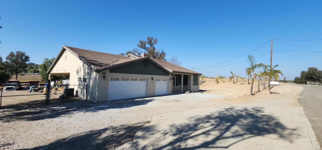 This beautifully updated home sits at the elevated top third pad on just over an acre of usable land, offering the perfect blend of style, comfort, and functionality. Freshly painted inside and out, the home is move-in ready and designed for both everyday living and entertainment. The Chefs kitchen has a 6 burner professional style stove with a grill and pot faucet. Two ovens, a low access microwave drawer, and a warming drawer. A prep counter with a second sink facing the casual seating of the large center island. Guest and family can enjoy your creations while you whip up the next course at expansive elevated slab granite island. The owners suite has French doors to a large side yare, ready for you to customize into your garden retreat, as well as a giant walk in closet, luxurious walk-in shower and sit down vanity. Two bedrooms and office are on the other side of the comfortable home. The office with built-in cabinets and drafting tabletop could easily be converted to an additional bedroom by simply removing the cabinets and adding a closet. A large laundry room sits between the home and huge Three car garage. Car enthusiasts and hobbyists will love the three-car garage wired with 220, complete with a drive-through lane to a covered carport, offering versatile parking and storage solutions. The lot lay out allows for easy access from two sides of the property. The R-A-1 zoning allows for horses, or light agricultural uses as well as just good old fashioned country living with quick access to 15, 215, and the 91 freeways. Add a horse or two, a barn and maybe an ADU for your own family compound. (Buyer to verify all information and options regarding the property.)