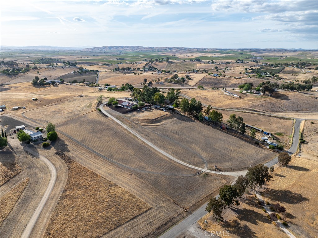 Welcome to 2245 Rancho Lomas Way, a picturesque ranch retreat nestled in the heart of Paso Robles’ Independence Ranch community. This expansive 2,260+/- single-level home, set on 10+/- acres, is a sanctuary for those seeking a blend of rustic charm and modern convenience. As you step through the front door, you are greeted by a spacious living room, boasting a wood-burning stove set against a brick accent wall, cathedral ceilings, and stunning views of the wine country landscape. Natural light floods the space, highlighting the thoughtful upgrades and meticulous attention to detail. Adjoining the living room is a dining area seamlessly connected to the remodeled kitchen. Here, culinary dreams come alive with newer cabinets, newer granite countertops, newer vinyl plank flooring, and a chic backsplash, all complemented by recessed lighting. The kitchen is a true heart of the home, designed for both intimate family dinners and grander gatherings as the French door opens to the rear yard where just around the corner, an artificial turf patio with a jacuzzi tub invites relaxation and social evenings under the stars. The primary suite is a private haven within the home, featuring cathedral ceilings and an attached bonus room—ideal for an office or fitness room—offering inspiring views of the sprawling hills. The en-suite bathroom is equally impressive with a newly tiled step-in shower, a large closet with built-in vanity, and ample cabinetry. The home also includes 2 additional bedrooms, each with newer flooring and unique touches such as a bonus playroom or study area in the 2nd bedroom, and a Jack and Jill bathroom attached to the 3rd bedroom. The 2-car garage has been converted to a game room (video games are to be included) boasting a full kitchen and separate entrance. The property's exterior is just as meticulously designed, featuring a carport adjacent to a brick patio set amongst refreshed landscaping. Equestrian enthusiasts will be drawn to the graded area with single stalls, various fenced spaces, and water connections, offering a variety possibilities to customize and create an equine environment. Owned solar panels and numerous outbuildings, including a Seatrain, provide functionality and opportunity, making this home not just a residence but a lifestyle choice. Embrace the opportunity to own a piece of Paso Robles serene landscapes at 2245 Rancho Lomas Way, where many sunsets may bring peace and a glimpse of the endless potential!